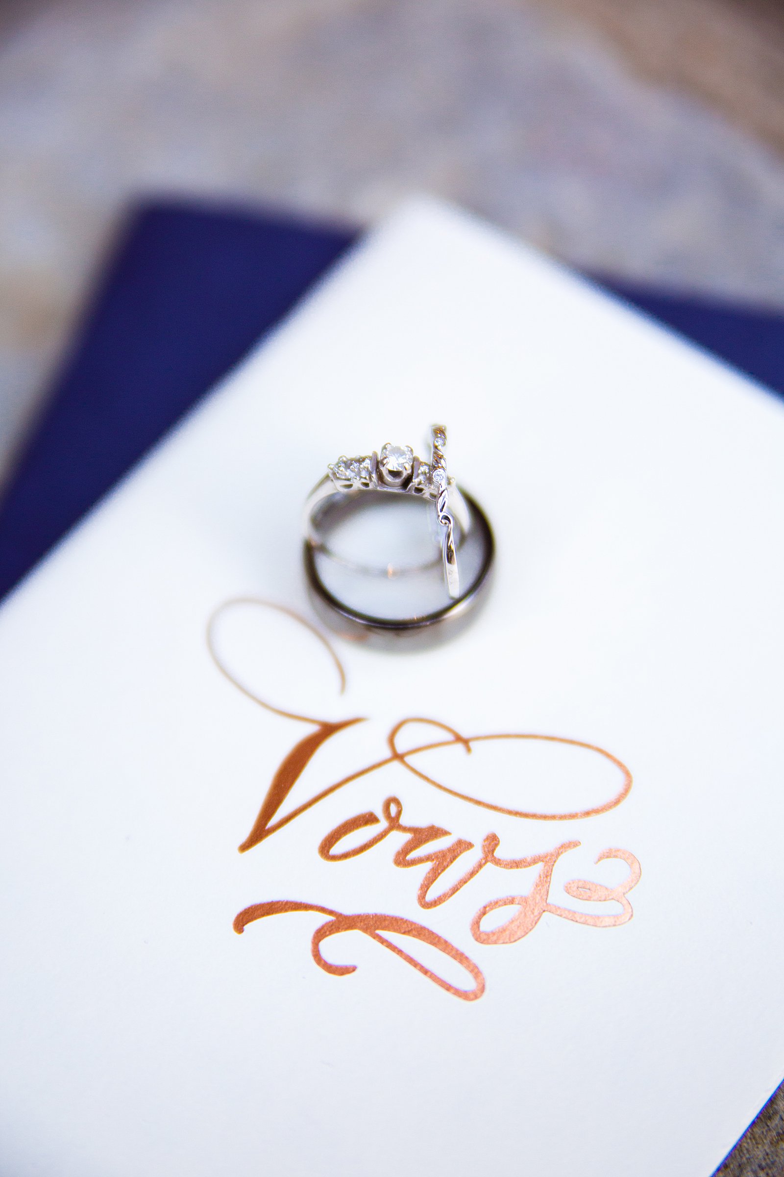 Bride and groom's wedding rings on top of their personal vow journals by PMA Photography.
