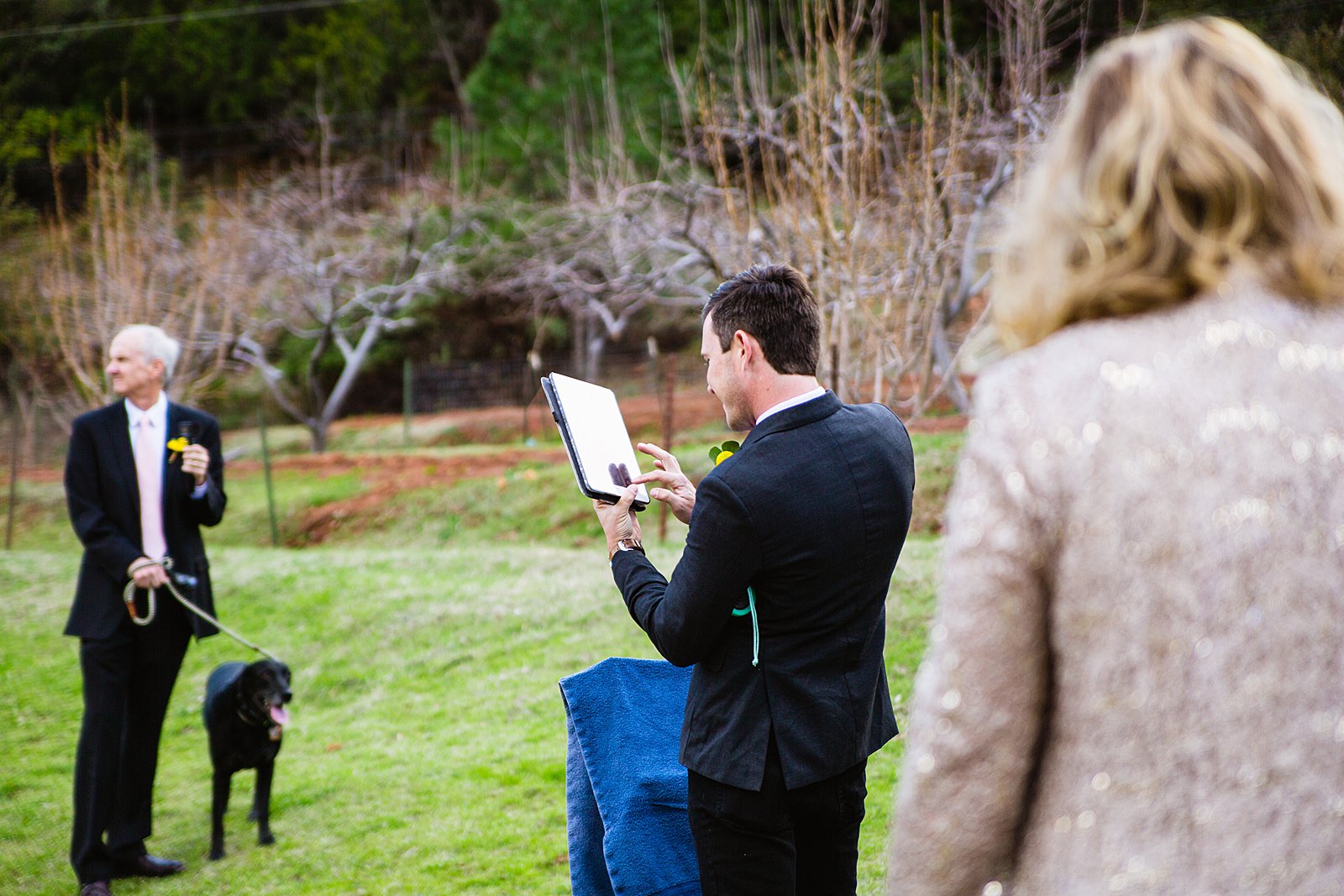 Bride's brother connecting to the wedding officiant via Skype by PMA Photography.