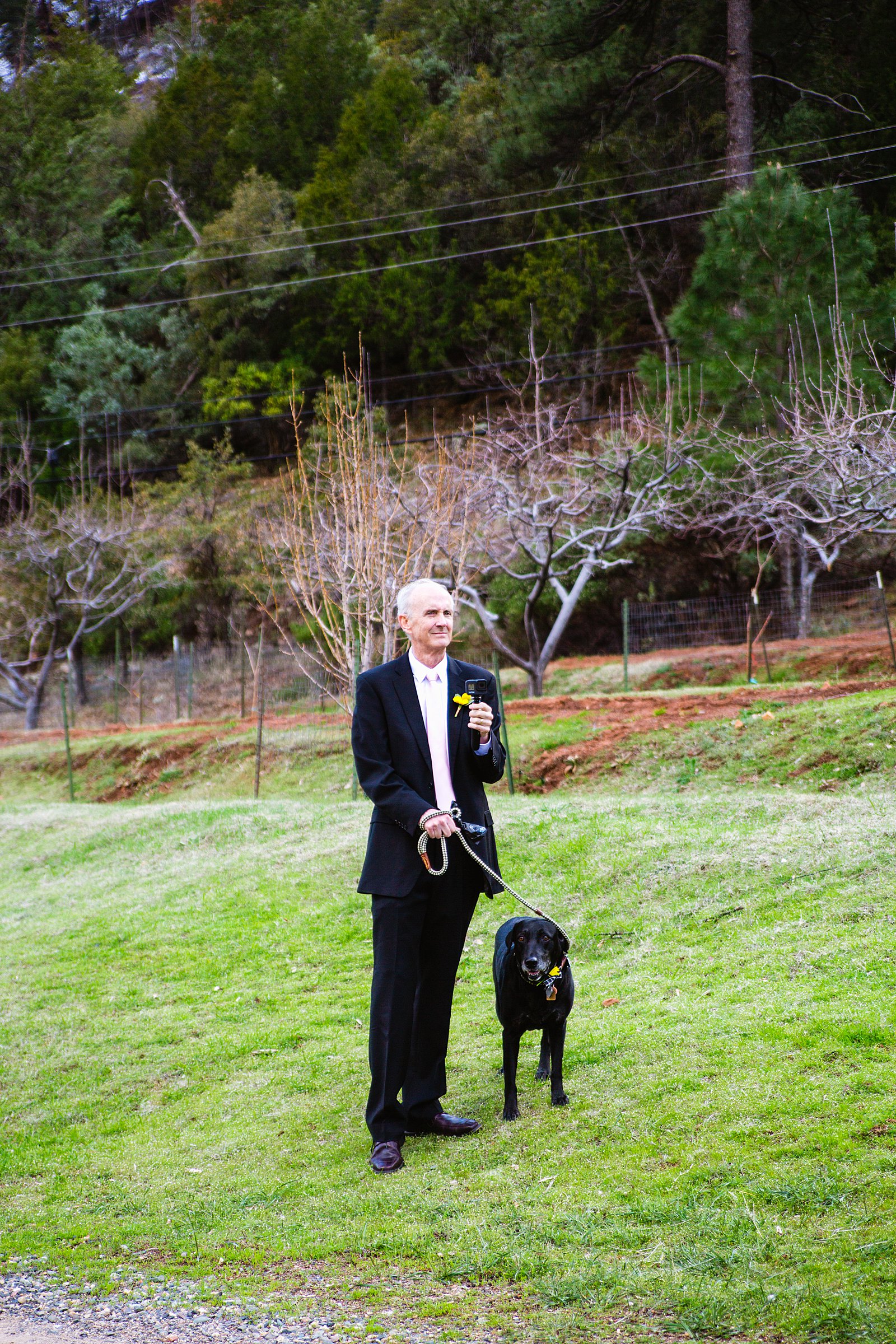 Bride's father holding their dog and a go pro during their Sedona elopement by PMA Photography.