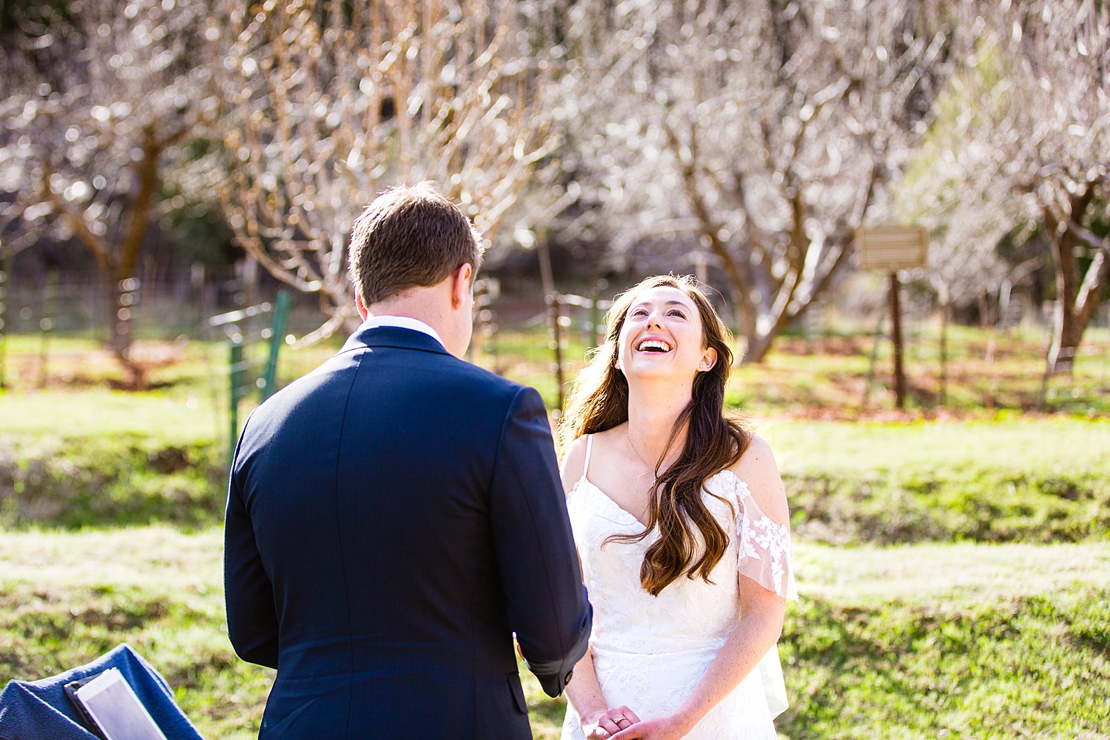Bride laughing with her groom during their wedding ceremony at Slide Rock by Sedona elopement photographer PMA Photography.
