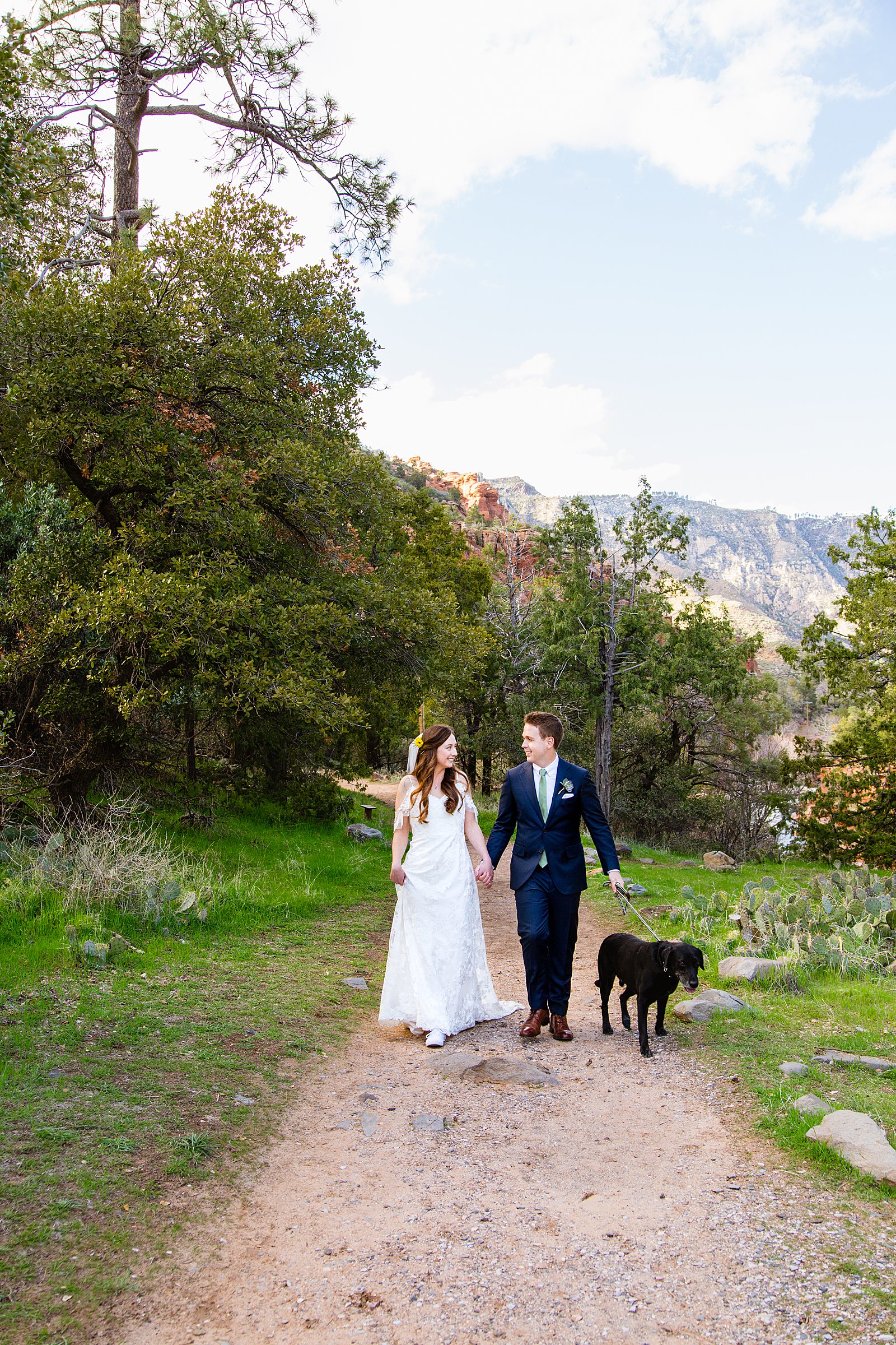 Bride and Groom walking together with their dog during their Slide Rock elopement by Sedona elopement photographer PMA Photography.