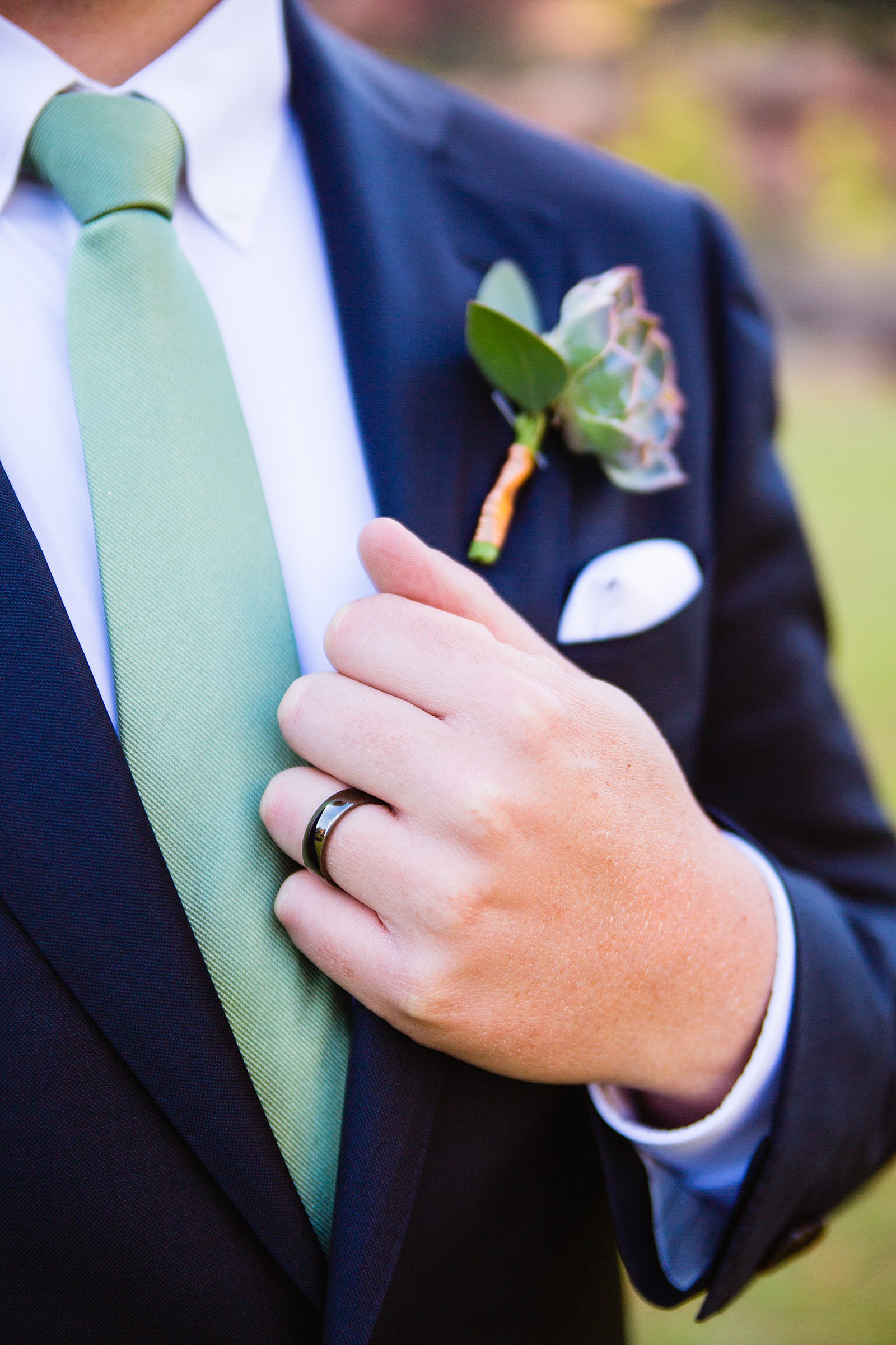 Groom's simple wedding ring on his navy and green suit by PMA Photography.
