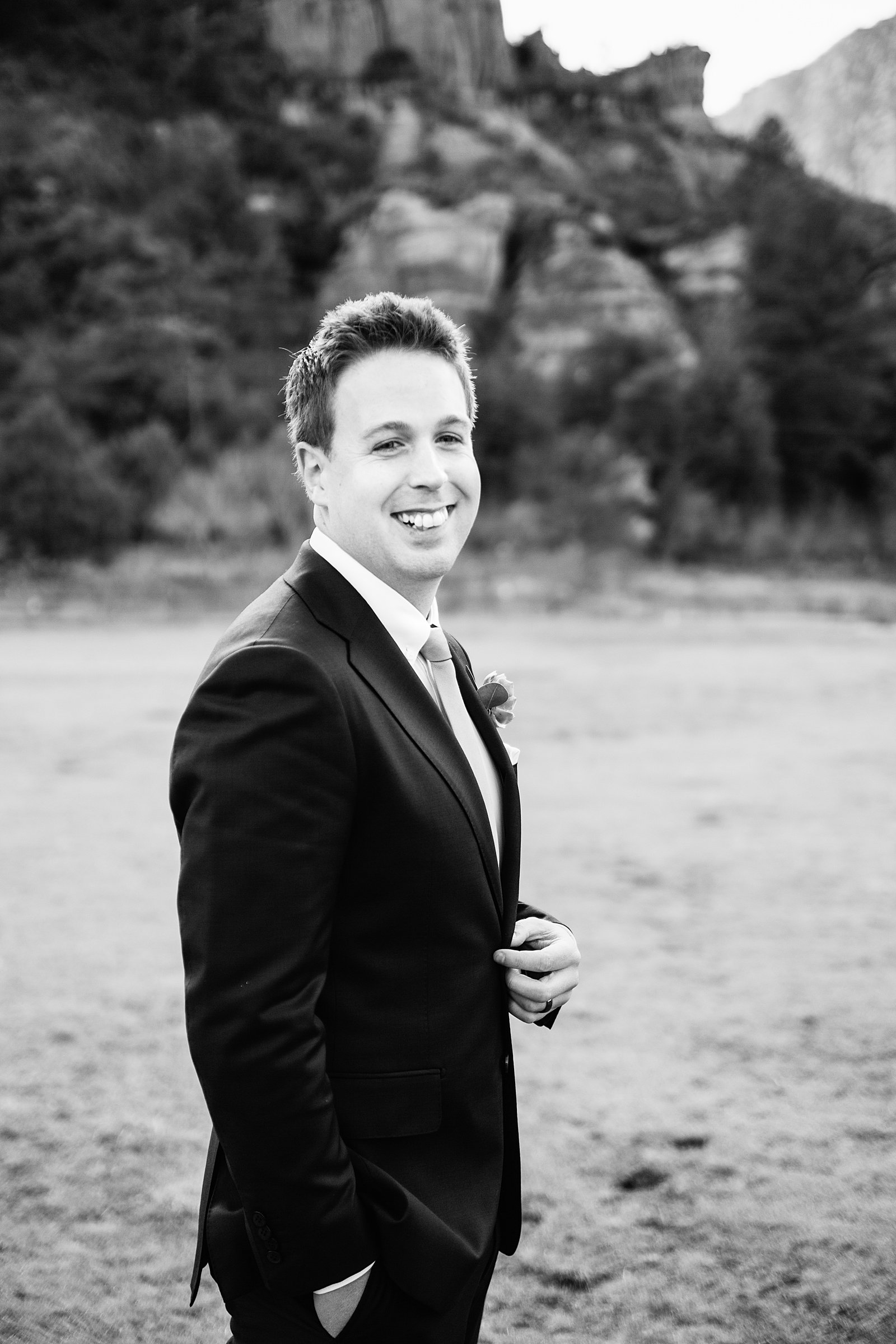Black and white image of groom laughing during his Sedona elopement by PMA Photography.