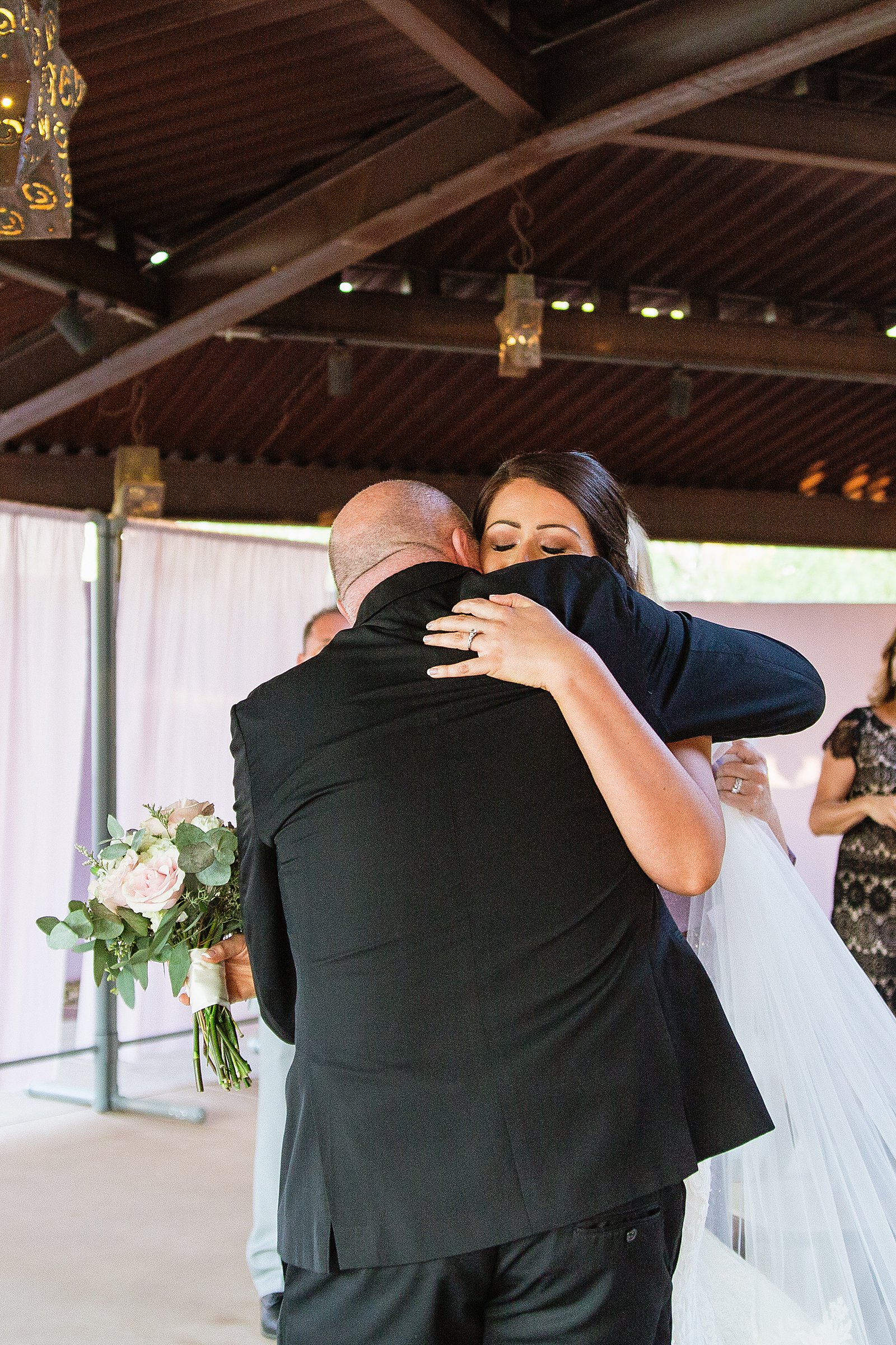 Bride hugging her father after walking down the aisle by PMA Photography.