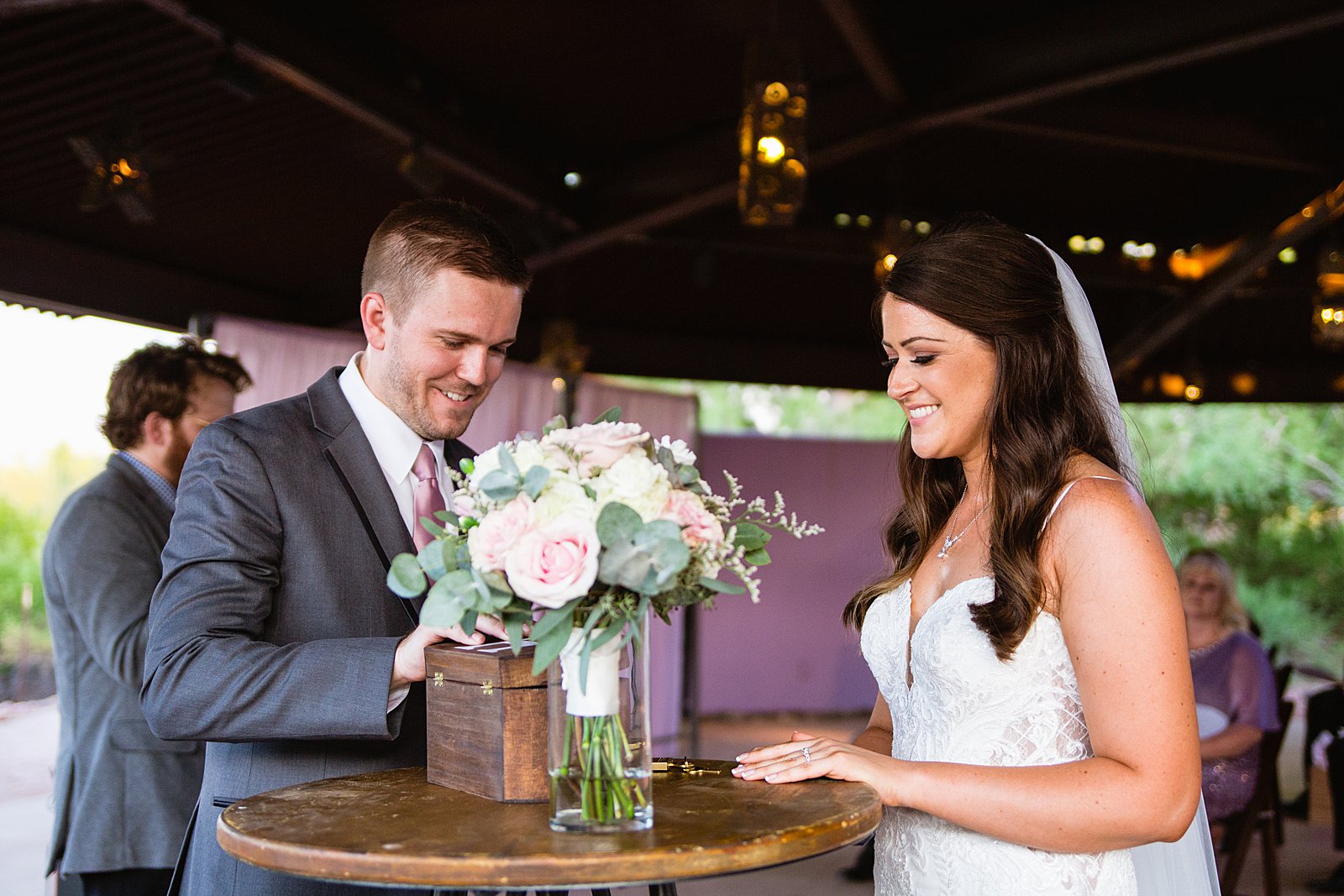 Bride and groom put letters to each other in a custom wooden lockbox during their Desert Botanical Garden weddingby Phoenix wedding photographer PMA Photography.