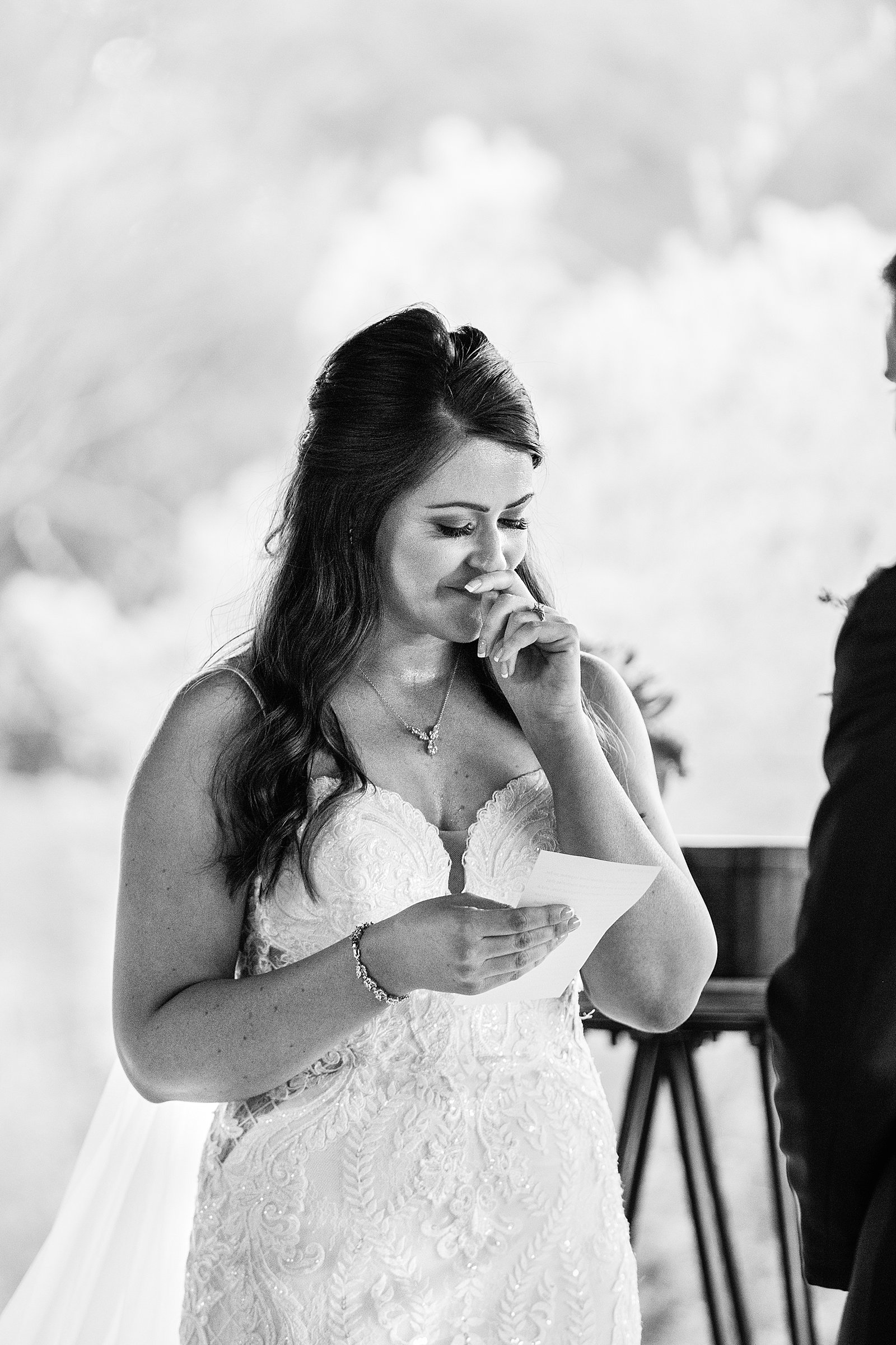 Bride getting emotion reading her vows during her wedding ceremony at Desert Botanical Gardens by Phoenix wedding photographer PMA Photography.