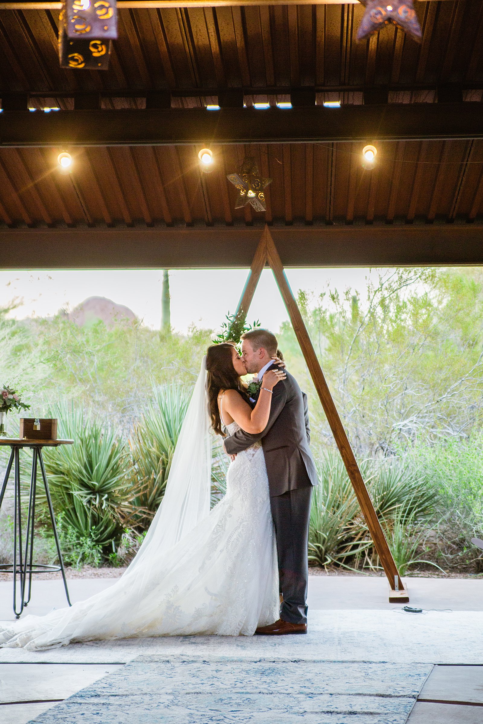 Bride and Groom share their first kiss during their wedding ceremony at Desert Botanical Gardens by Arizona wedding photographer PMA Photography.