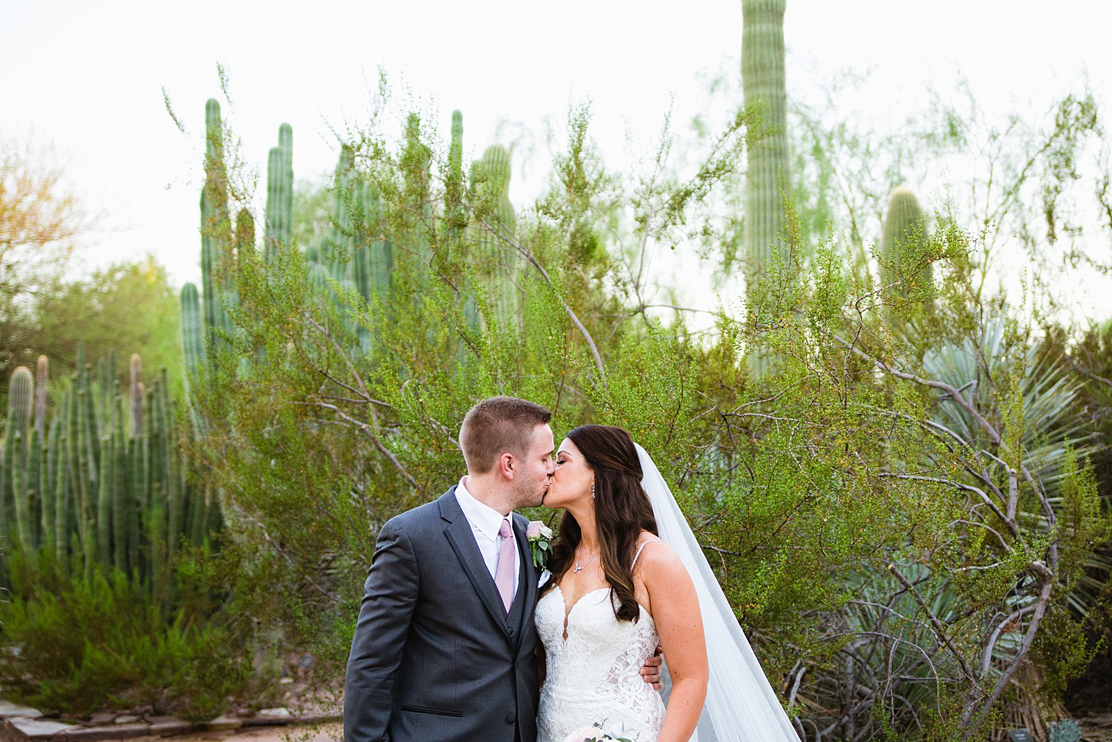 Bride and Groom share a kiss during their Desert Botanical Gardens wedding by Phoenix wedding photographer PMA Photography.