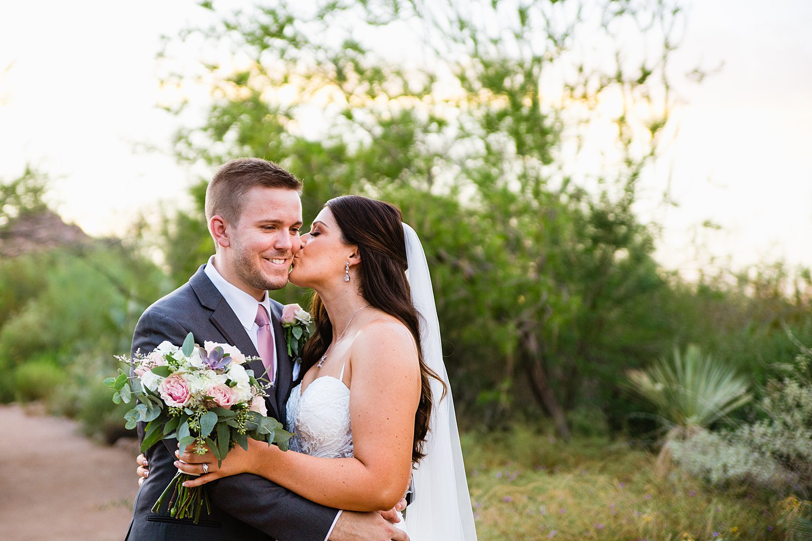 Bride and Groom share a kiss during their Desert Botanical Gardens wedding by Arizona wedding photographer PMA Photography.