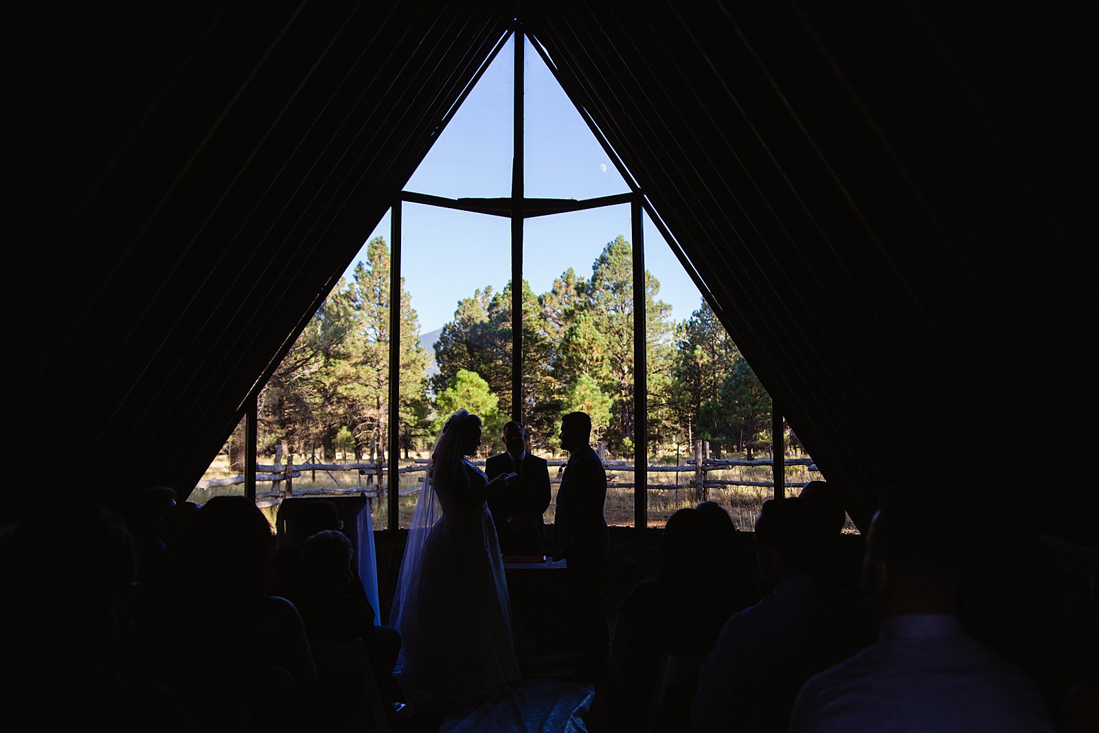 Silhouette of the bride and groom during their Chapel of the Holy Dove wedding ceremony by Arizona wedding photographer PMA Photography.