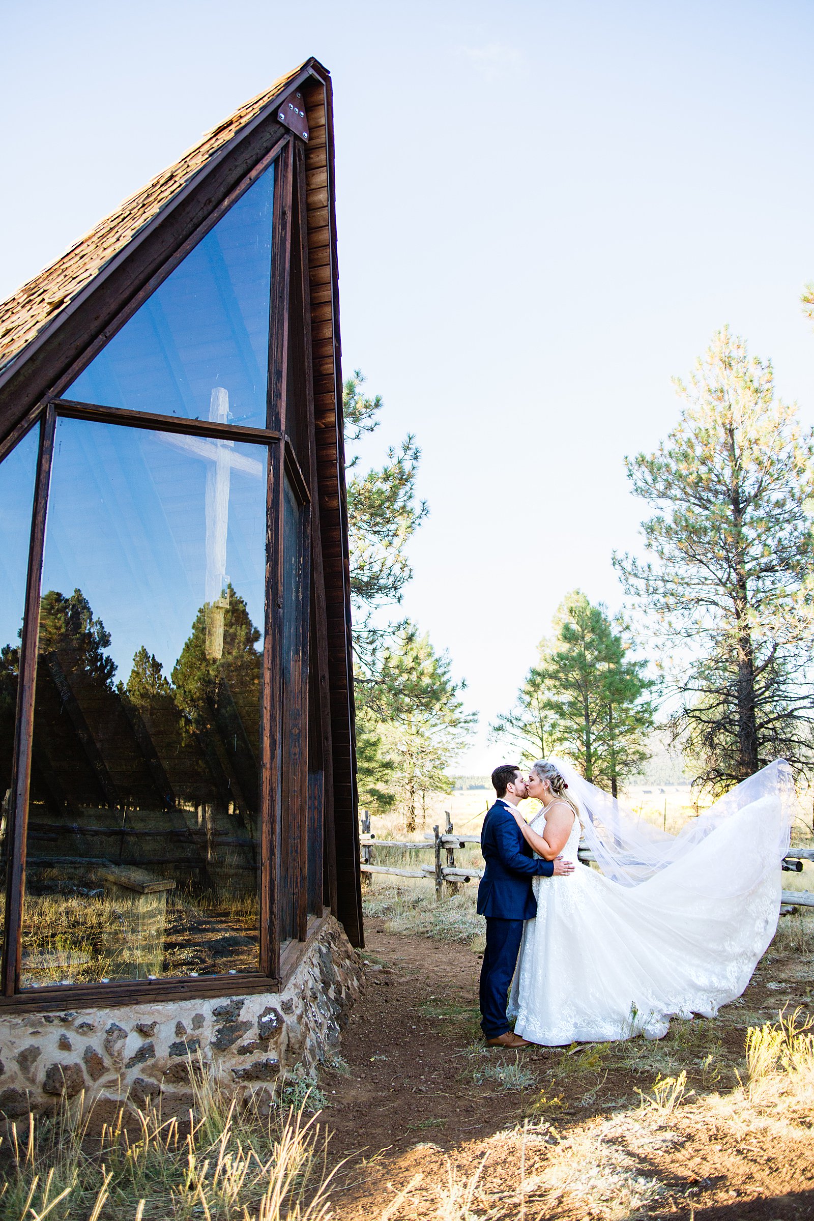 Bride and groom pose for an epic photo at Chapel of the Holy Dove by Flagstaff wedding photographer PMA Photography.