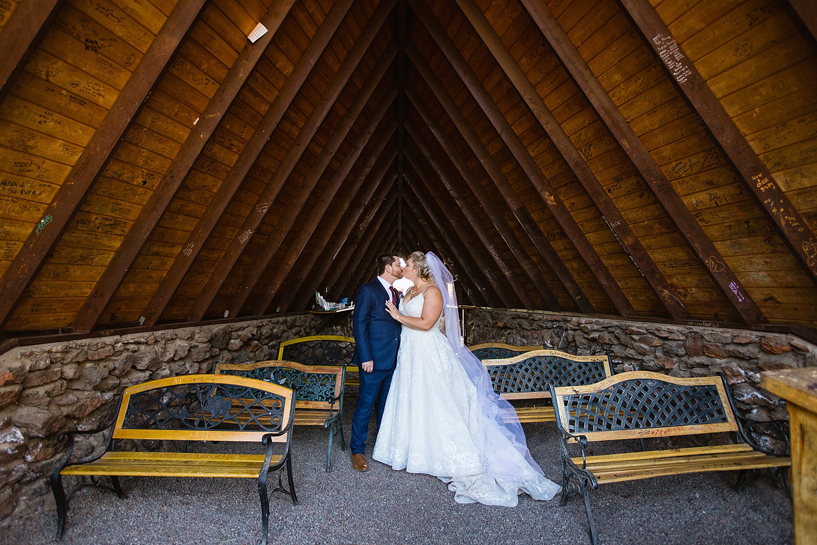 Bride and groom share a kiss in the Chapel of the Holy Dove by Arizona wedding photographers PMA Photography.