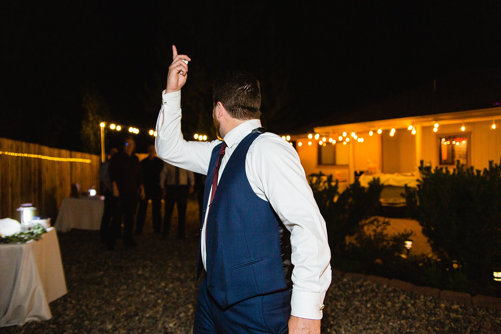 Garter toss at backyard wedding reception by Flagstaff wedding photographer PMA Photography.