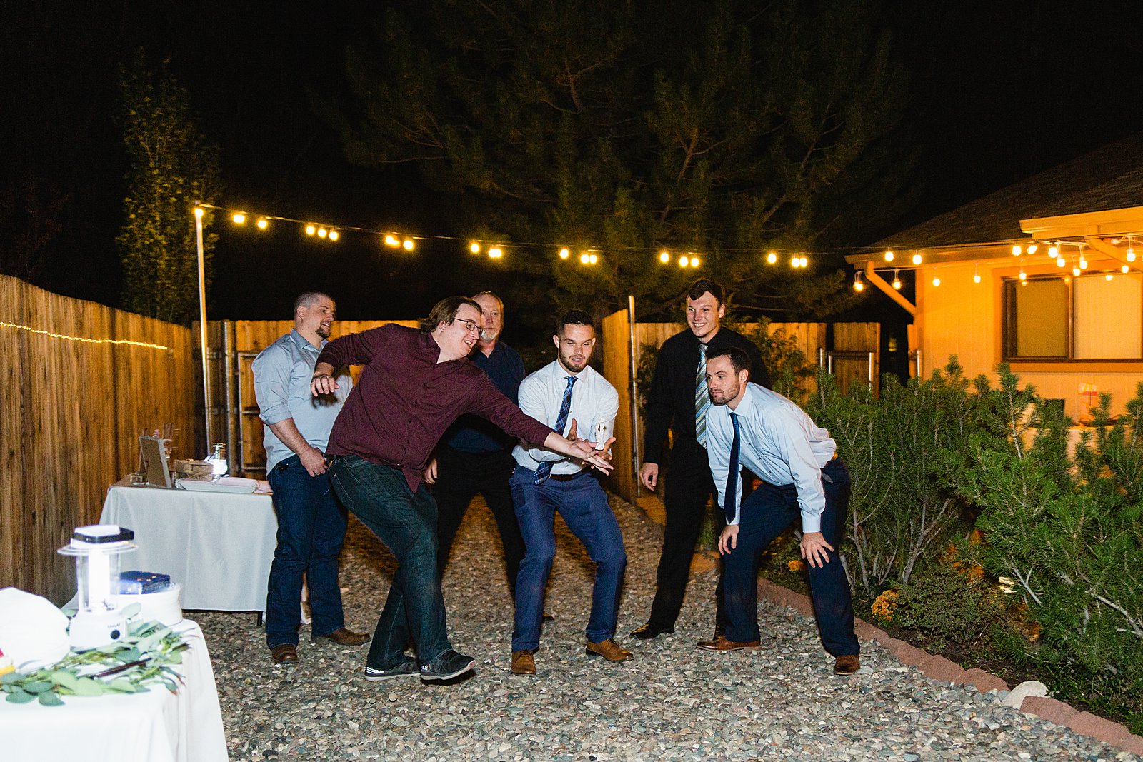 Garter toss at backyard wedding reception by Flagstaff wedding photographer PMA Photography.