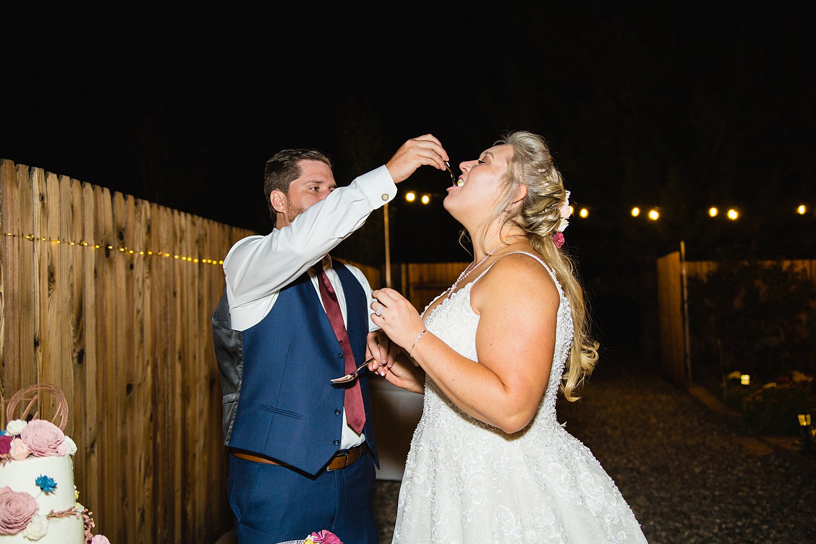 Bride and Groom cutting their wedding cake at their backyard wedding reception by Arizona wedding photographer PMA Photography.