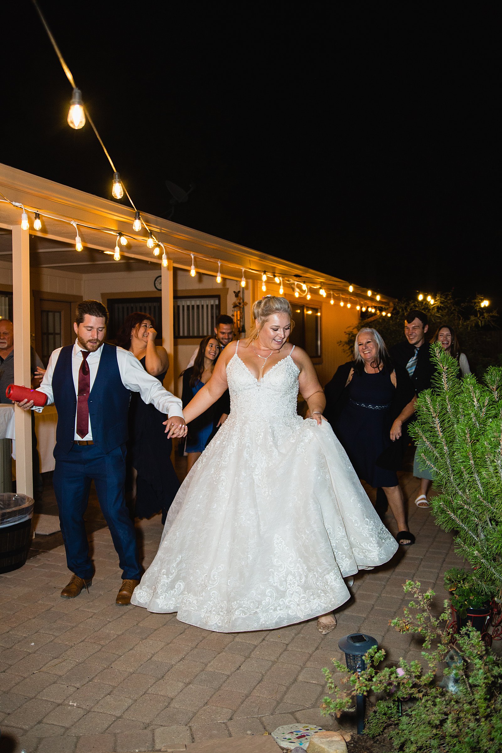 Bride and Groom dancing with guests at their backyard wedding reception by Arizona wedding photographer PMA Photography