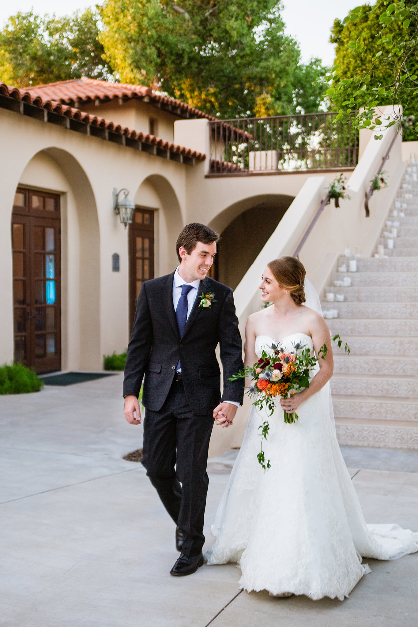 Bride and Groom walking together during their Secret Garden Events wedding by Phoenix wedding photographer PMA Photography.
