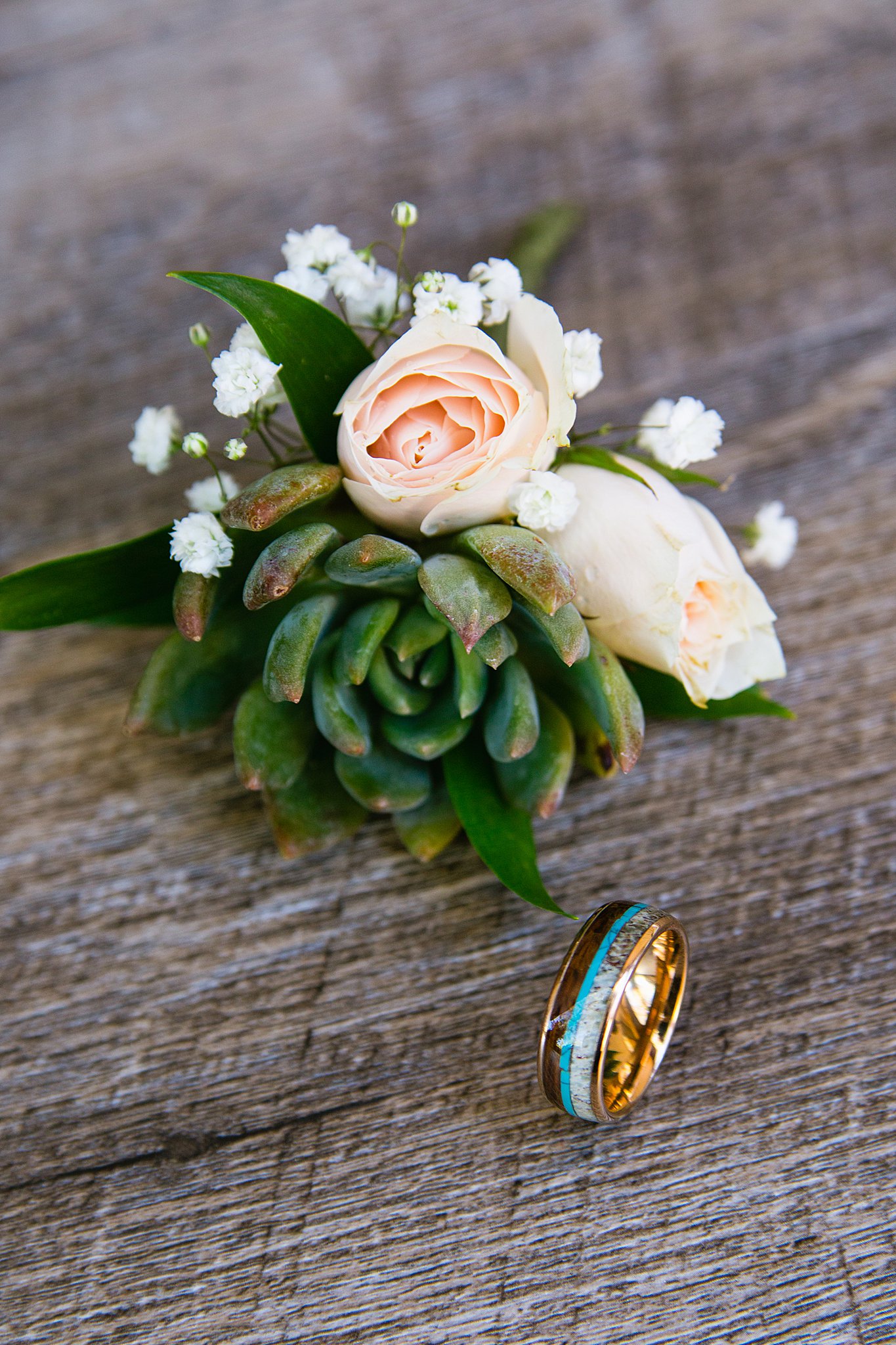 Groom's custom wedding ring with antler, turquoise, and wood with a succulent and rose boutonniere by Arizona wedding photographer PMA Photography.