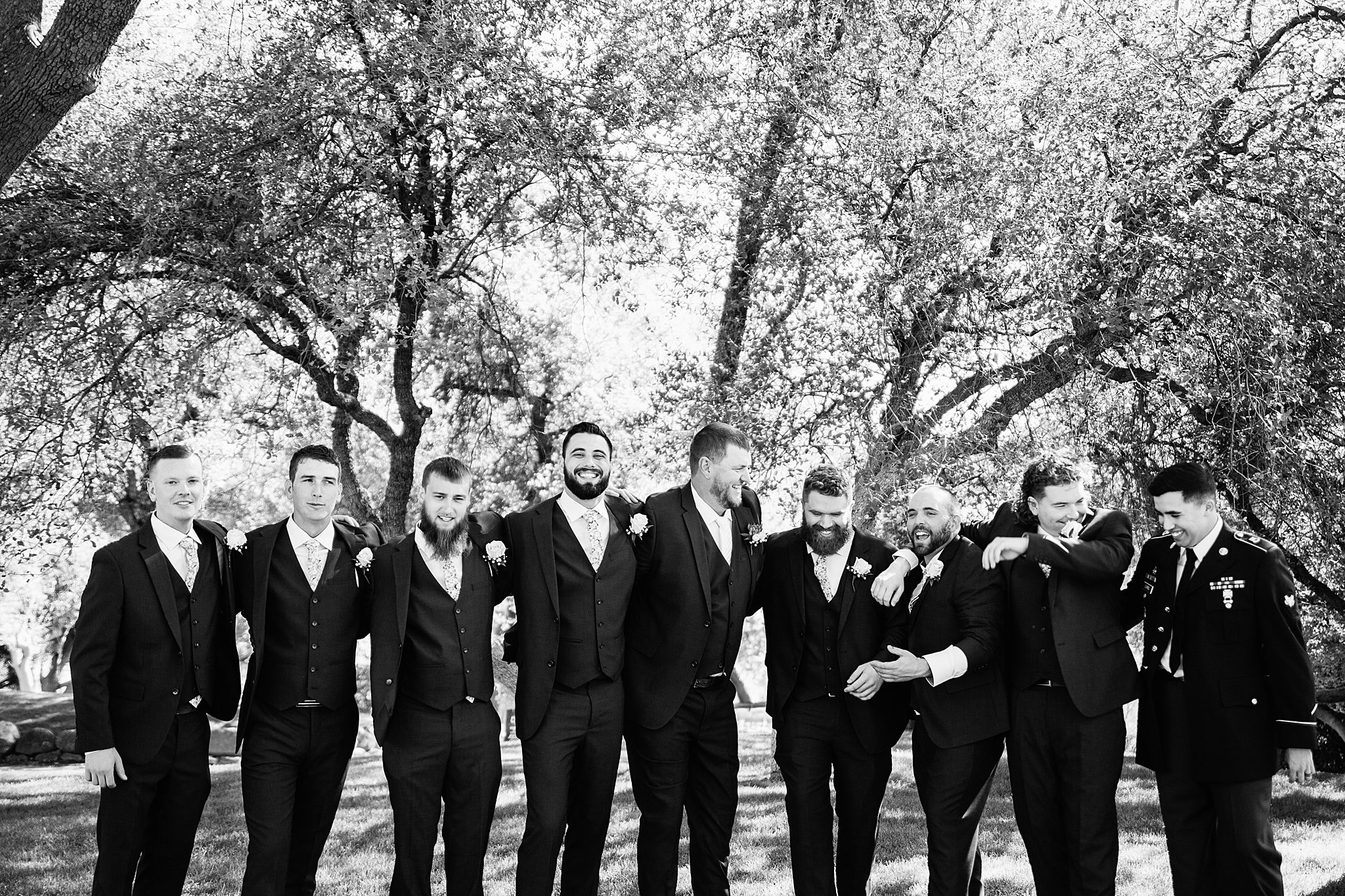 Groom and groomsmen laughing together at Van Dickson Ranch wedding by Skull Valley wedding photographer PMA Photography.
