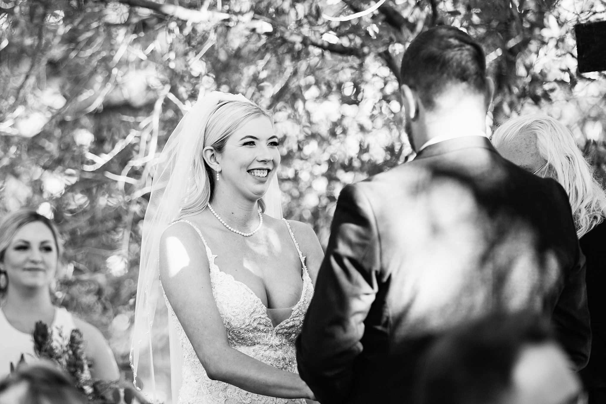 Bride looking at her groom during their wedding ceremony at Van Dickson Ranch by Skull Valley wedding photographer PMA Photography.