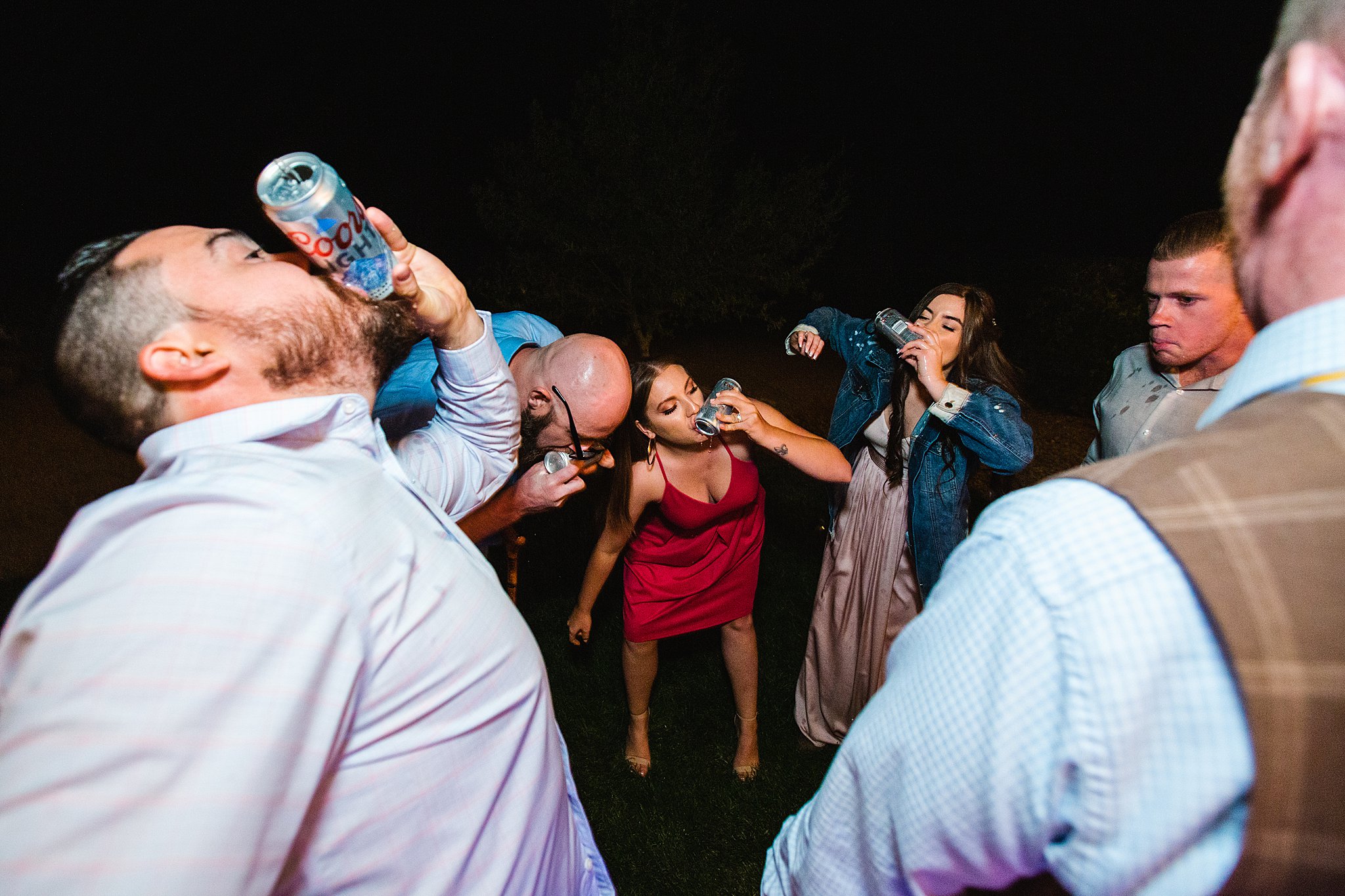 Guests shotgunning beers at a Van Dickson Ranch wedding by PMA Photography.