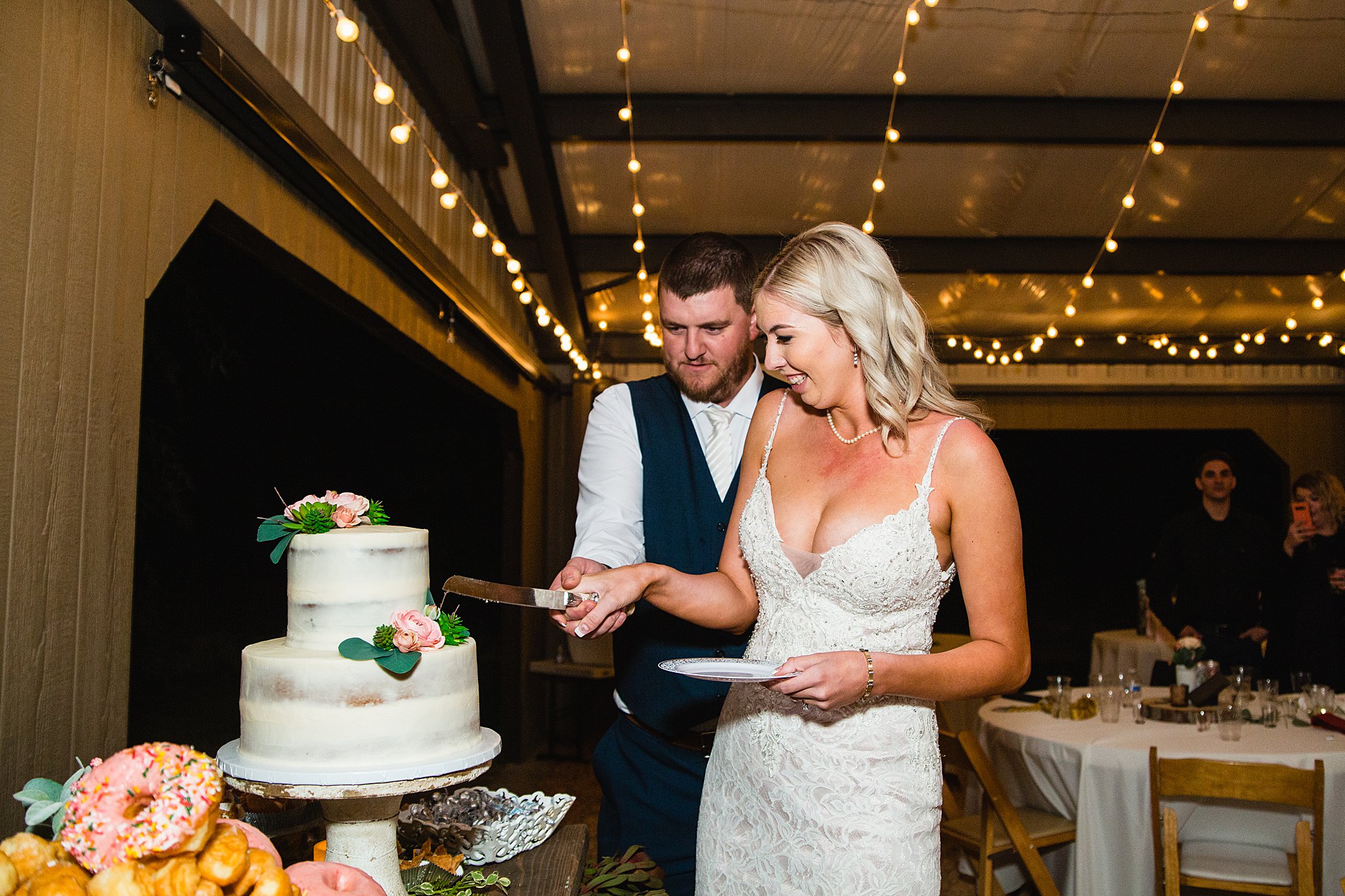 Bride and Groom cutting their wedding cake at their Van Dickson Ranch wedding reception by Arizona wedding photographer PMA Photography.
