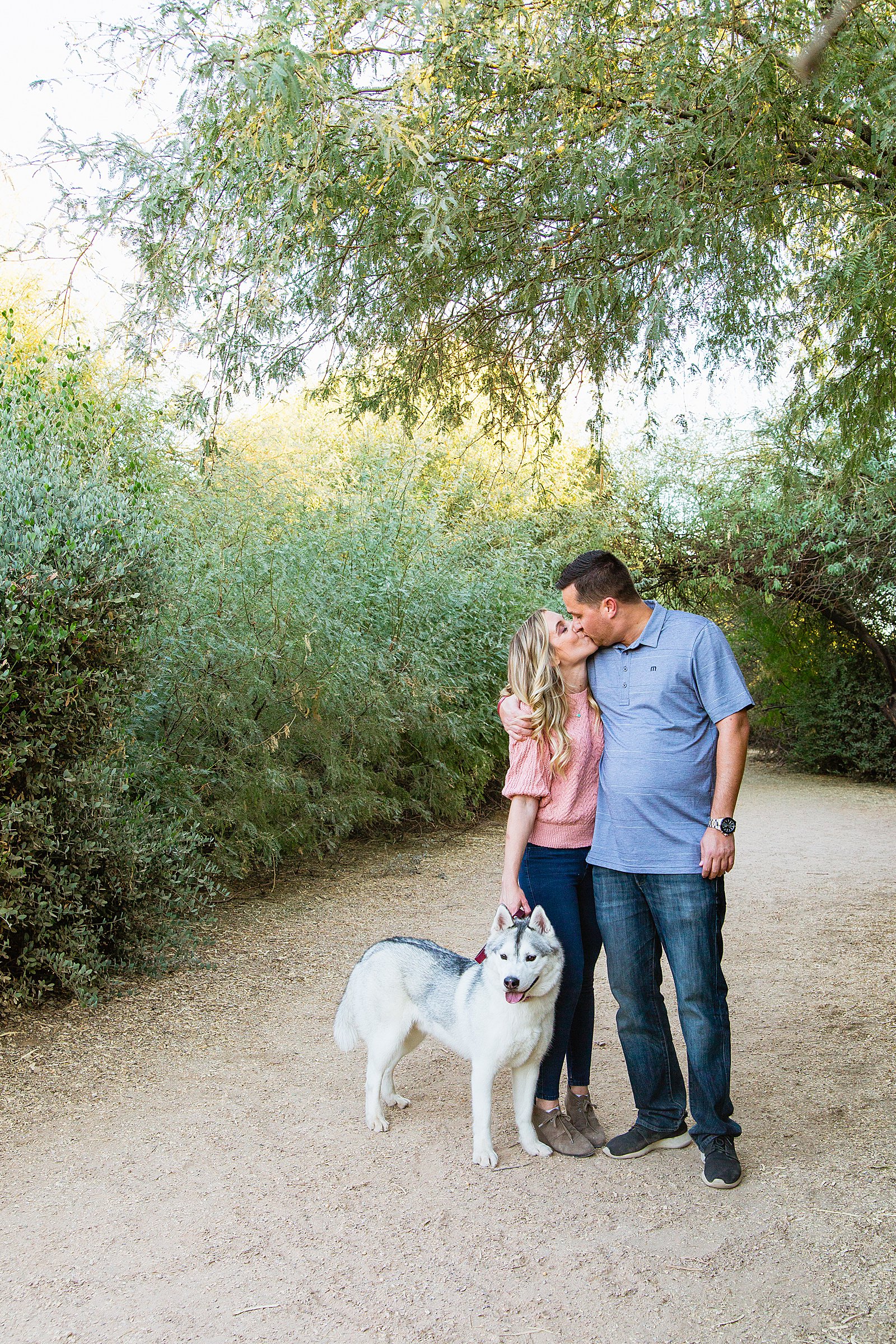 Couple pose with their dog for their Riparian Preserve at Water Ranch engagement session by Gilbert wedding photographer PMA Photography.