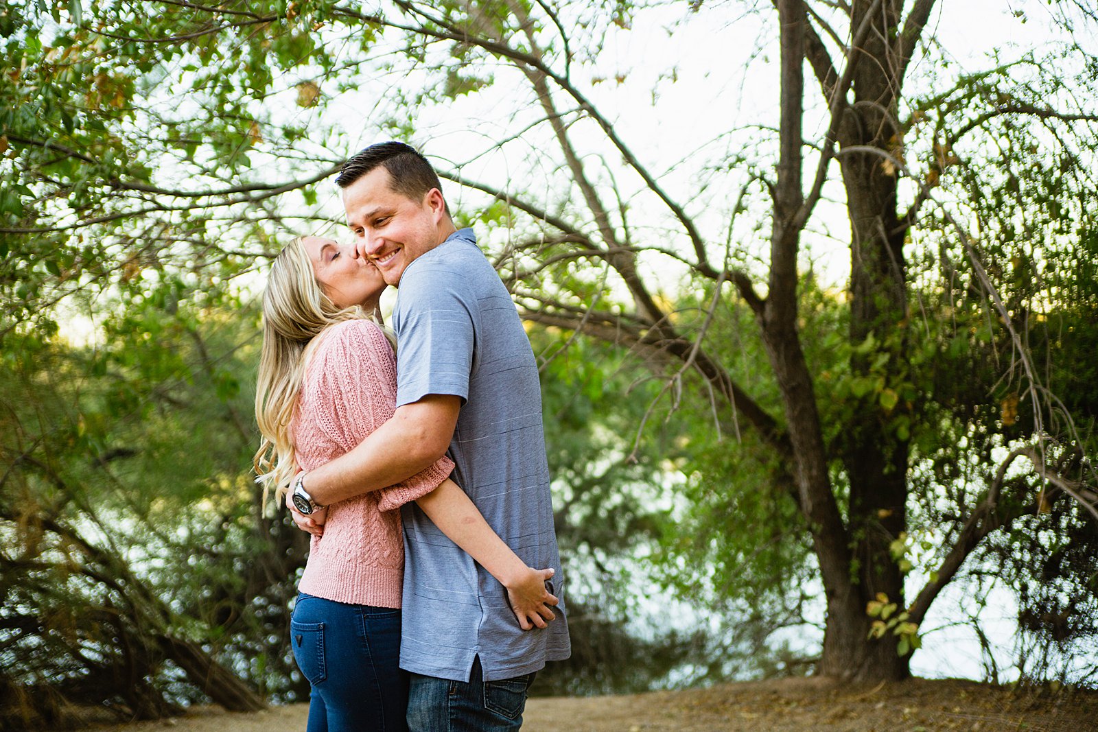 Couple share a kiss during their Riparian Preserve at Water Ranch engagement session by Gilbert wedding photographer PMA Photography.