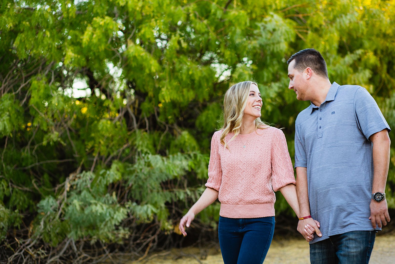 Couple walking together during their Riparian Preserve at Water Ranch engagement session by Gilbert engagement photographer PMA Photography.