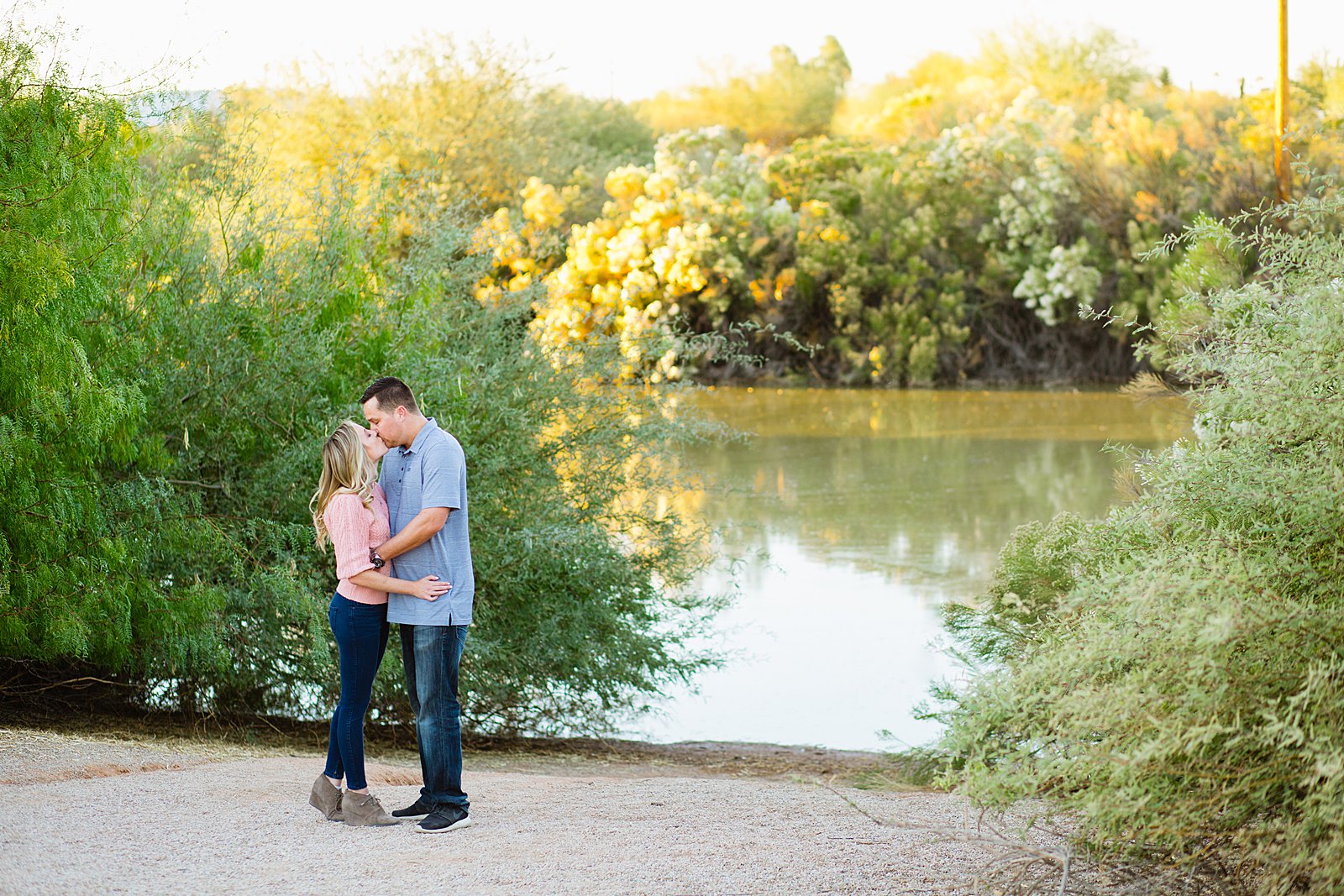 Couple share a kiss during their Gilbert engagement session by Arizona wedding photographer PMA Photography.