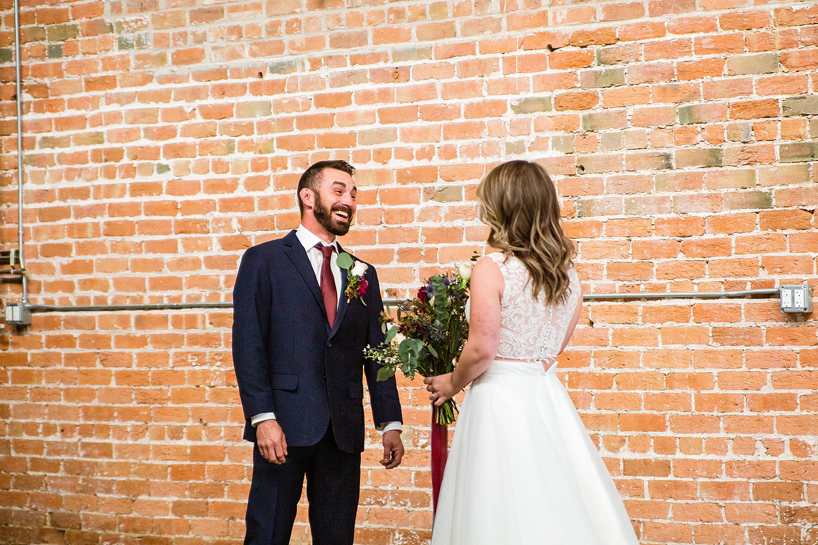 Bride and Groom share an intimate moment during their first look at Sunkist Warehouse by Phoenix wedding photographer PMA Photography.