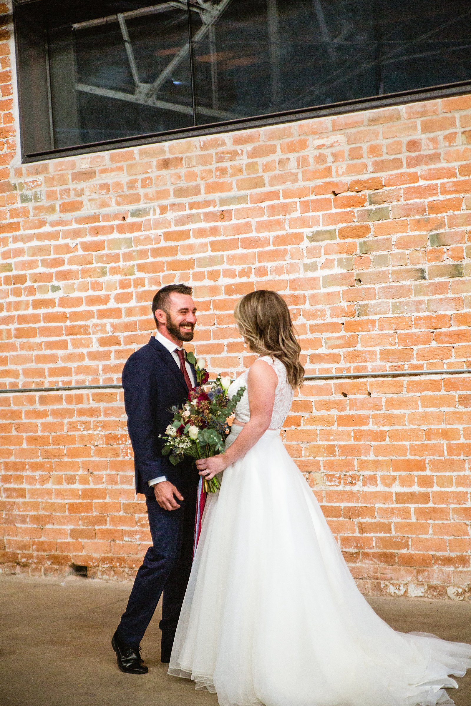 Bride and Groom share an intimate moment during their first look at Sunkist Warehouse by Phoenix wedding photographer PMA Photography.