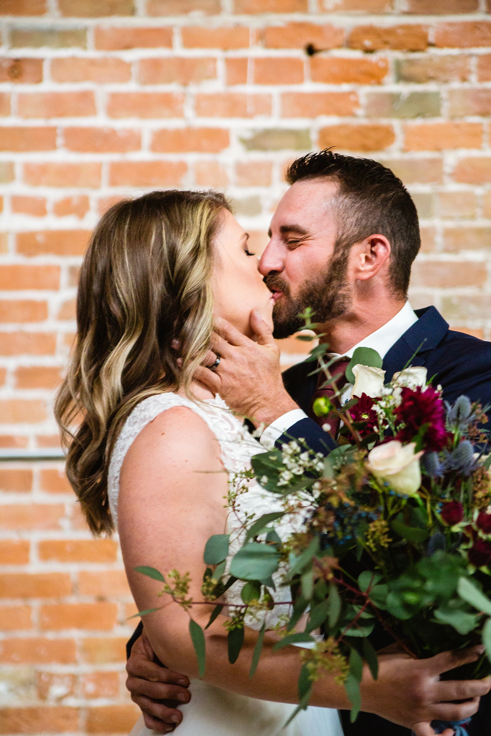 Bride and Groom share a kiss during their Sunkist Warehouse wedding by Arizona wedding photographer PMA Photography.
