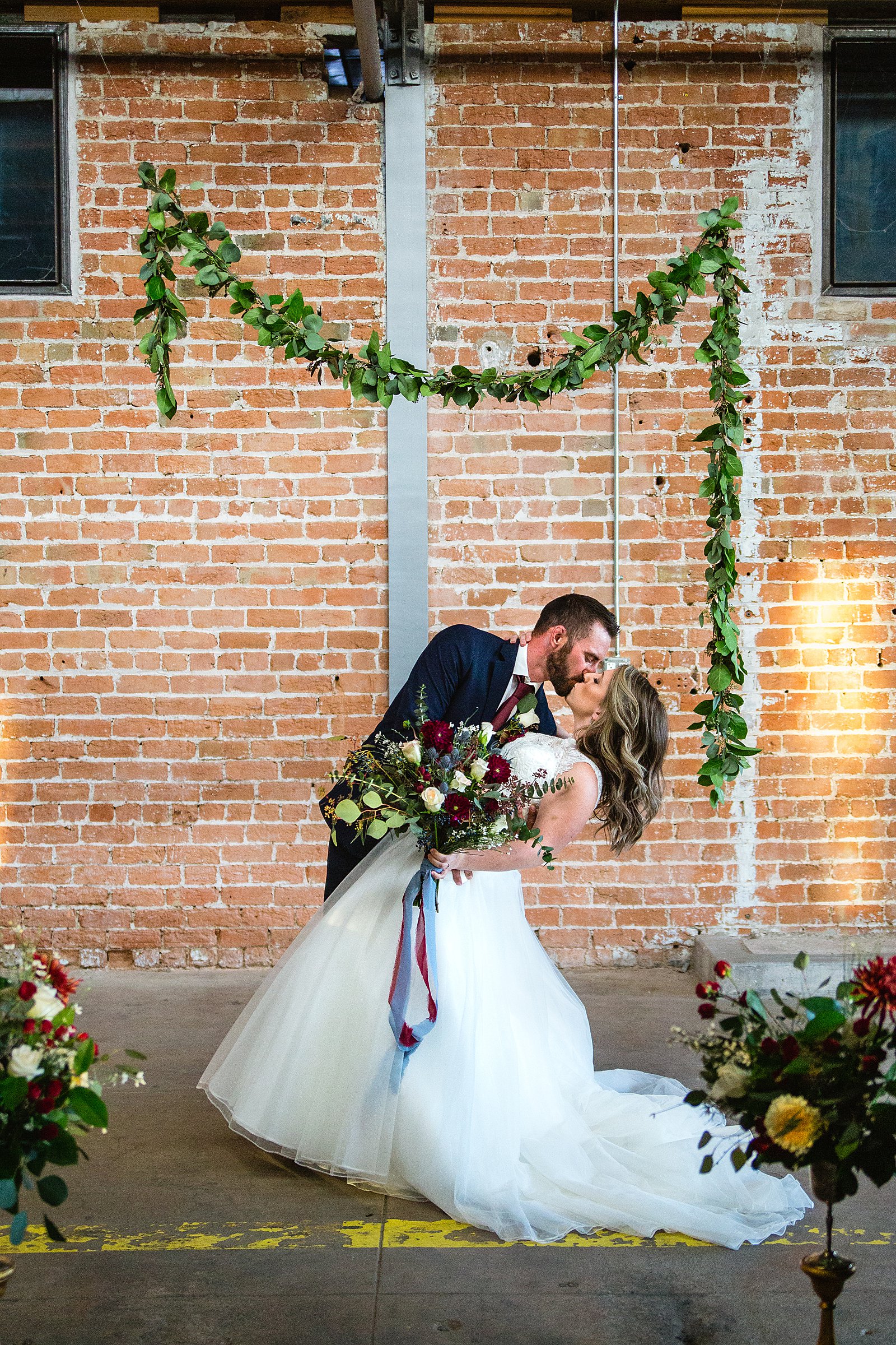 Bride and Groom share a kiss during their Sunkist Warehouse wedding by Mesa wedding photographer PMA Photography.