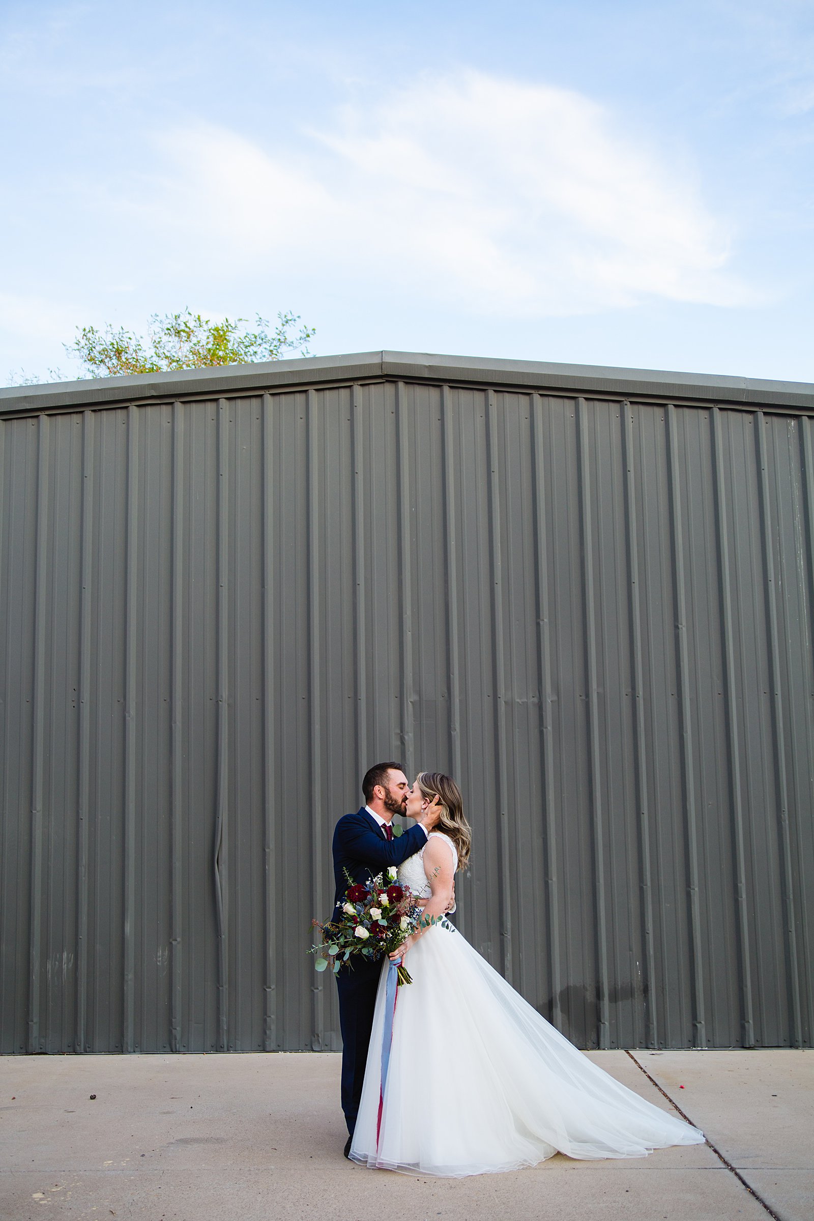 Bride and Groom share a kiss during their Sunkist Warehouse wedding by Arizona wedding photographer PMA Photography.