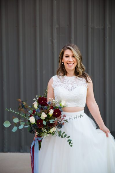 Bride with a simple and romantic wedding dress with a jewel toned bouquet by Phoenix wedding photographers PMA Photography.