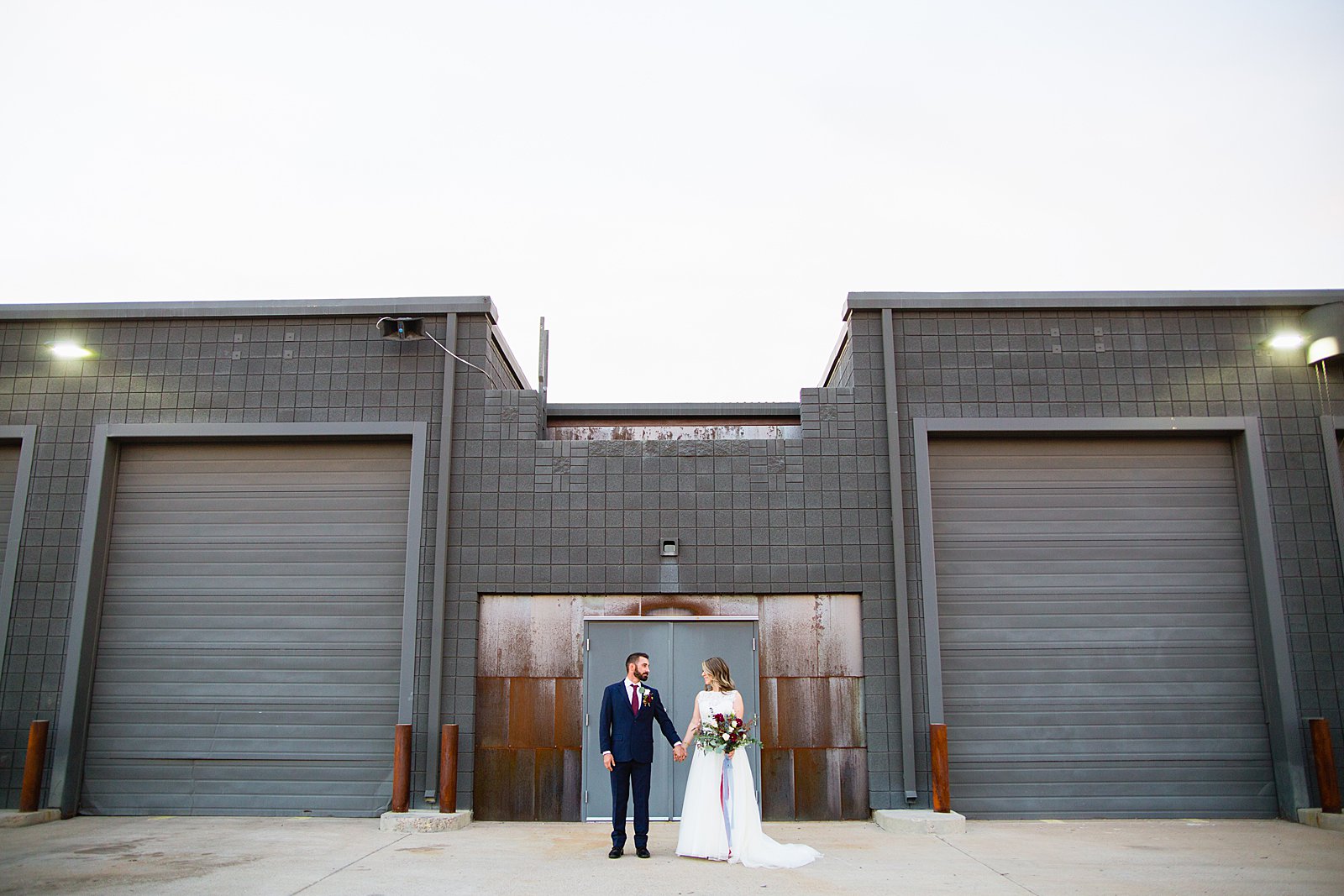 Bride and Groom pose during their Sunkist Warehouse wedding by Arizona wedding photographer PMA Photography.