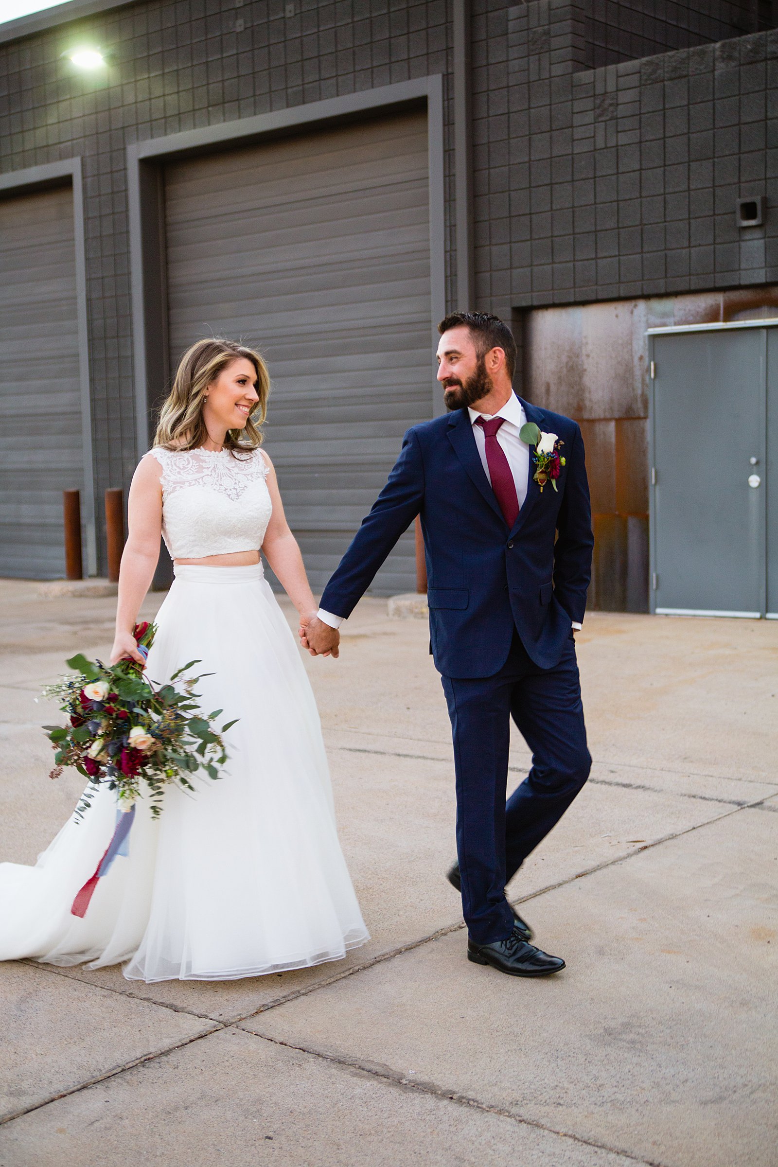 Bride and Groom walking together during their Sunkist Warehouse wedding by Arizona wedding photographer PMA Photography.