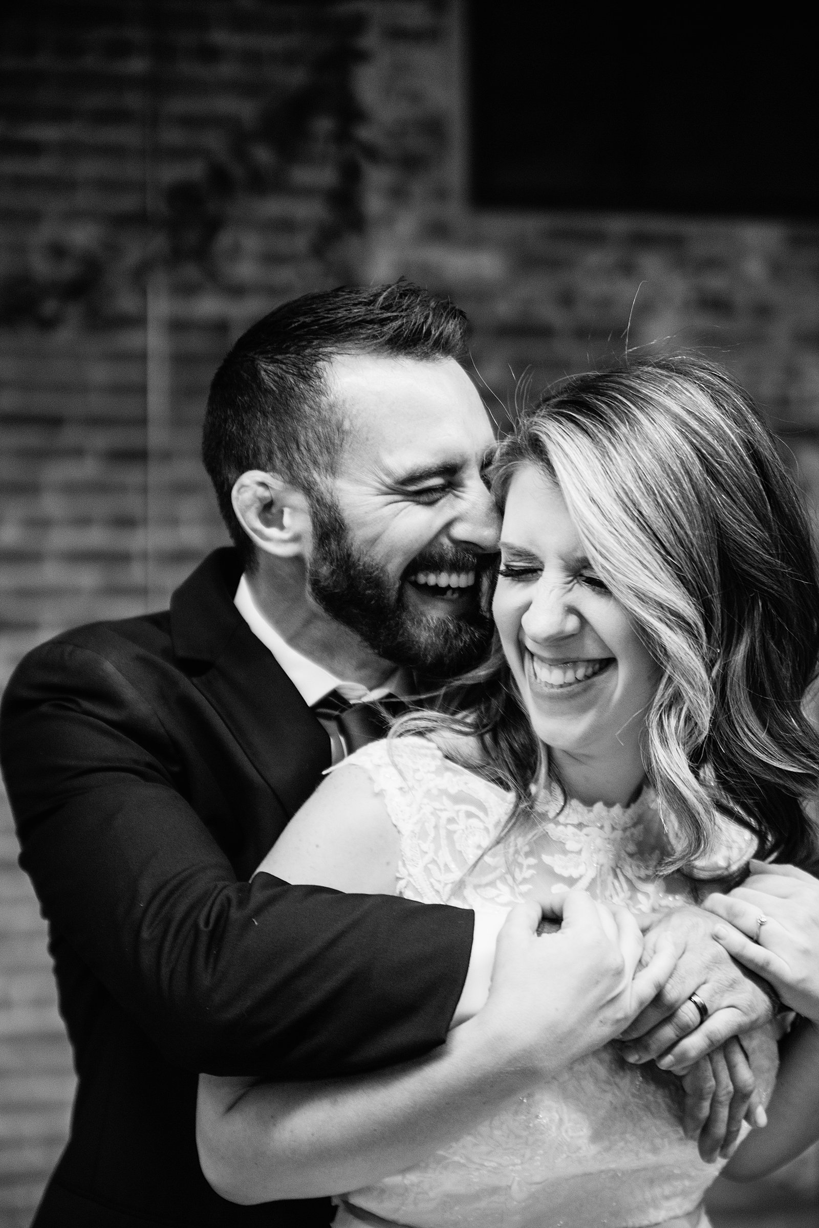 Bride and Groom laughing together during their Sunkist Warehouse wedding by Arizona wedding photographer PMA Photography.