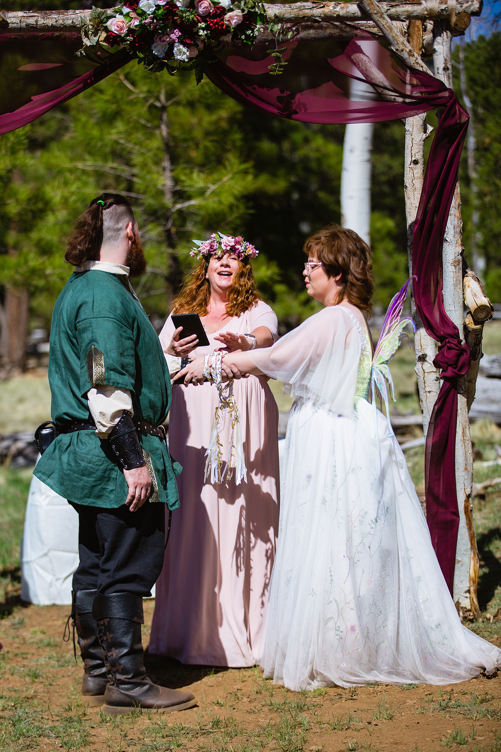 Couple share a handfasting during their Arizona Nordic Center wedding by Flagstaff wedding photographer PMA Photography.