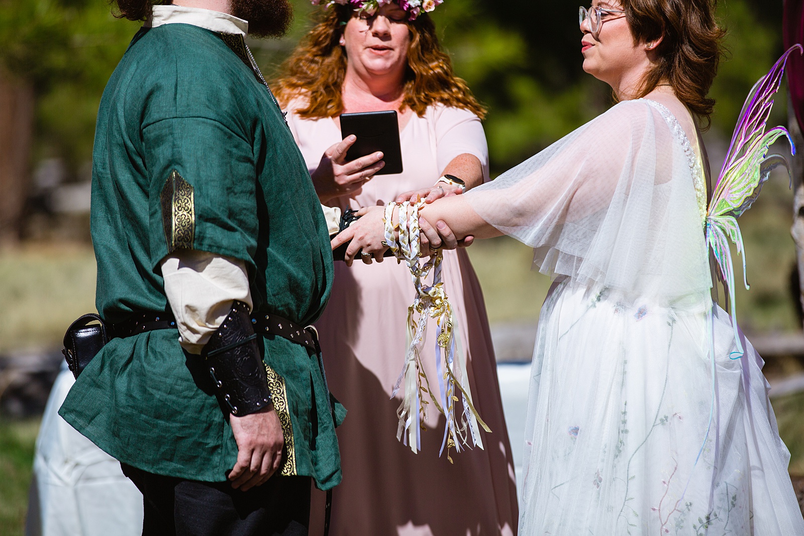 Couple share a handfasting during their Arizona Nordic Center wedding by Flagstaff wedding photographer PMA Photography.