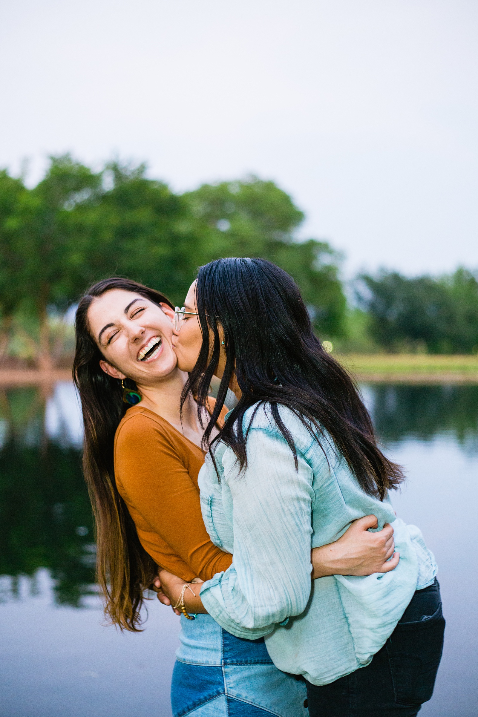 LGBTQ+ couple laugh together during their Anthem Park engagement session by Phoenix engagement photographer PMA Photography.