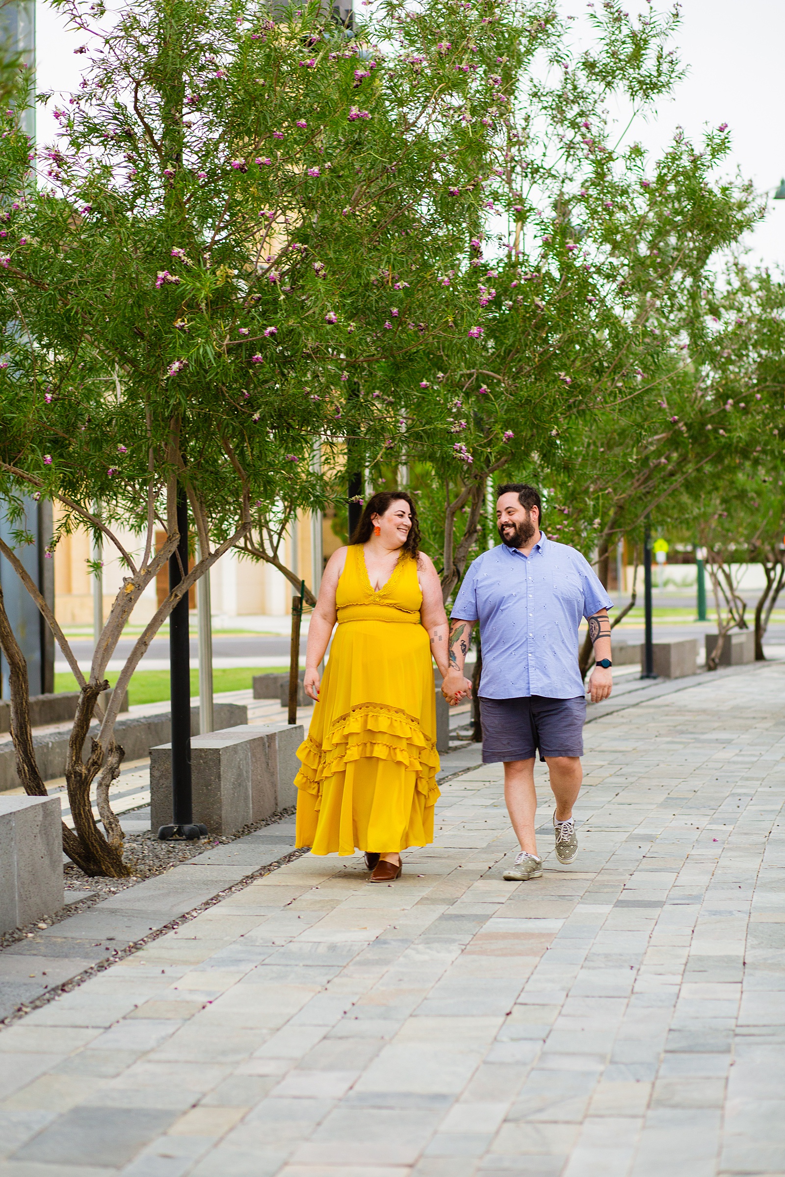 Couple walking together during their Mesa Arts Center engagement session by Mesa engagement photographer PMA Photography.