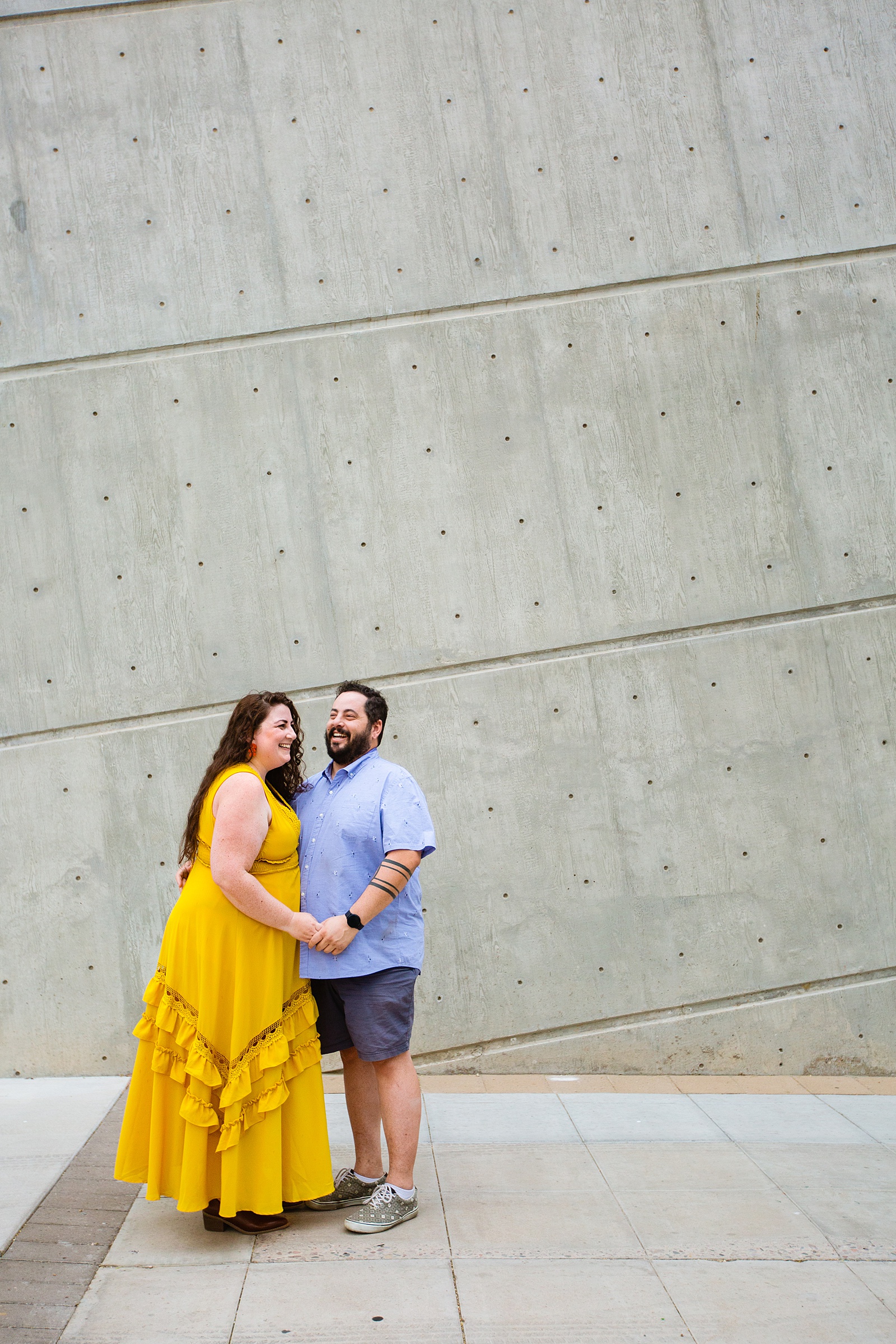 Couple laugh together during their Mesa Arts Center engagement session by Mesa engagement photographer PMA Photography.