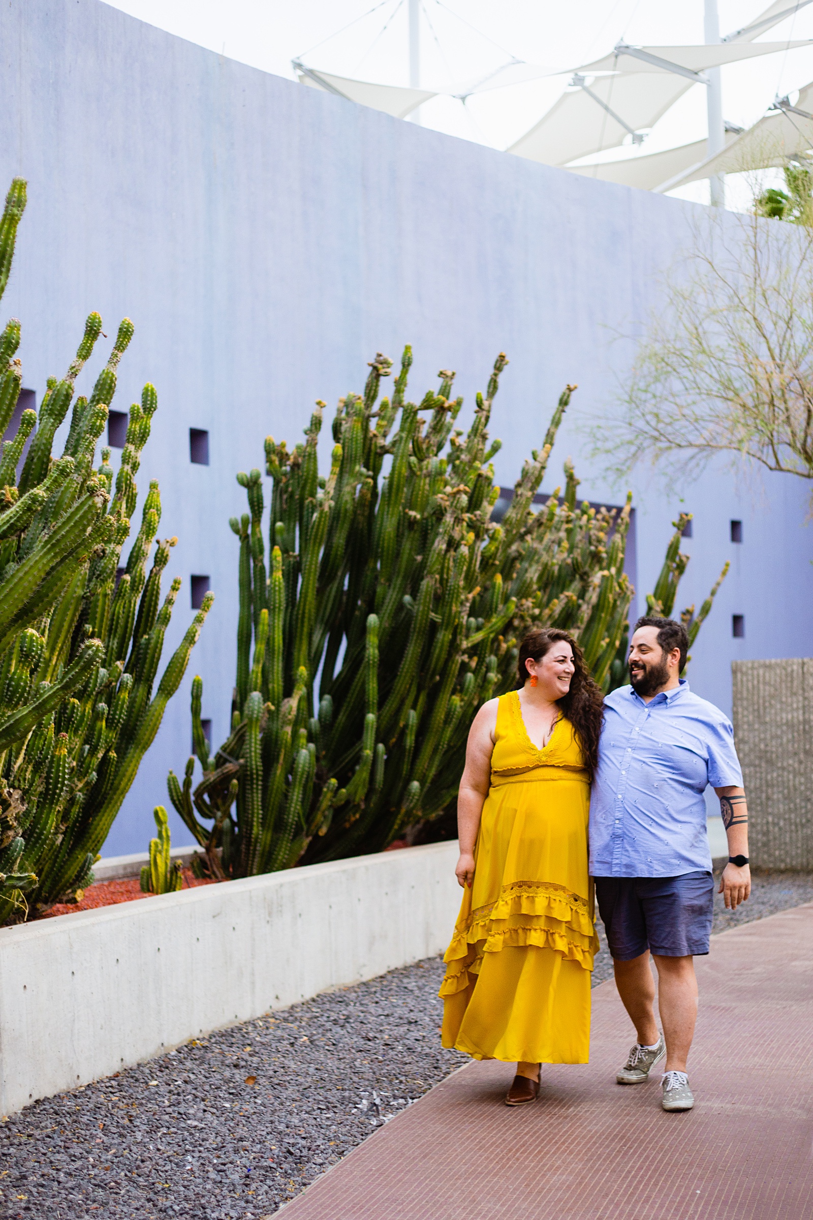 Couple walking together during their Mesa Arts Center engagement session by Mesa engagement photographer PMA Photography.
