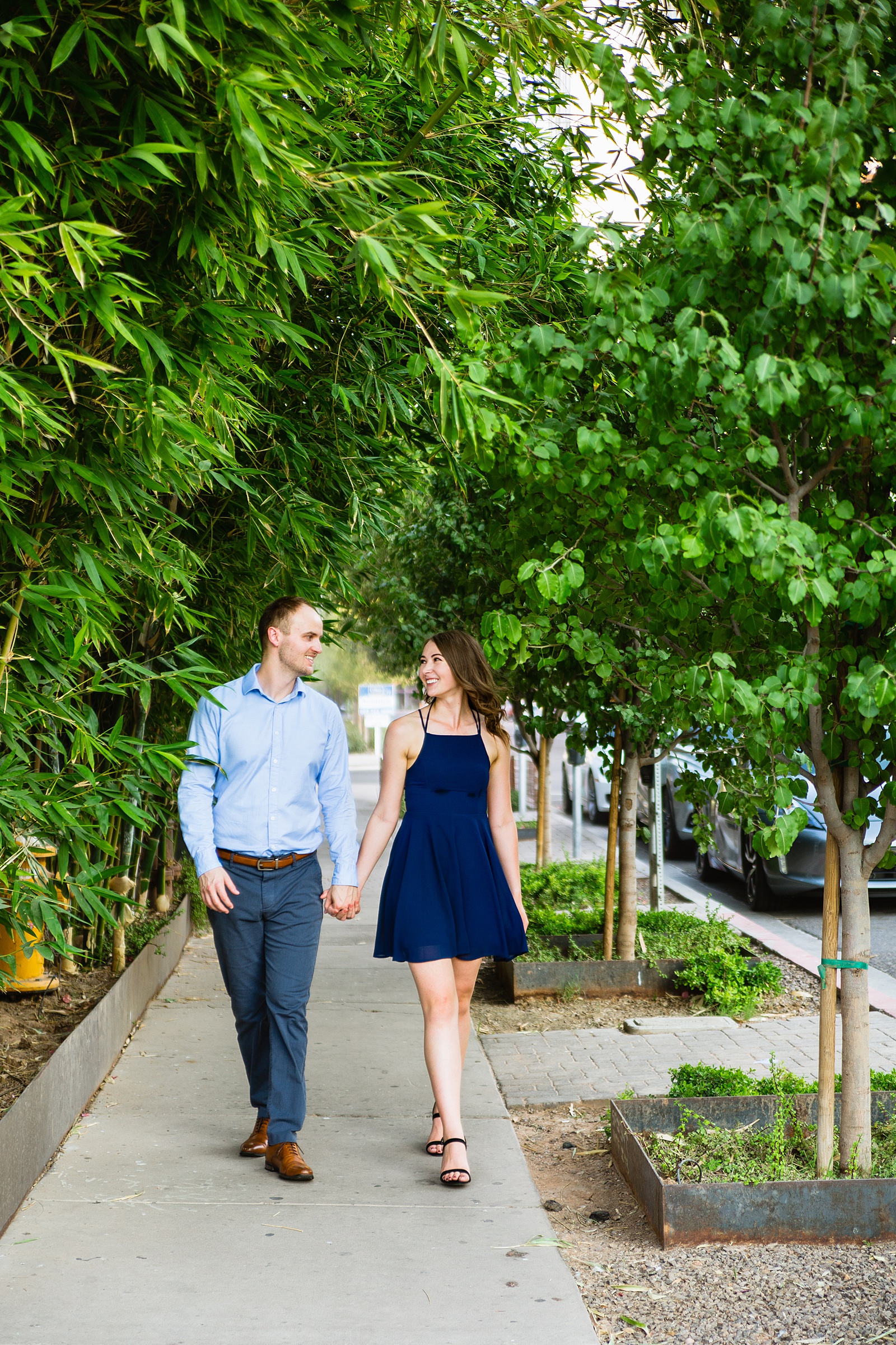 Couple walking together during their Roosevelt Row engagement session by Phoenix engagement photographer PMA Photography.