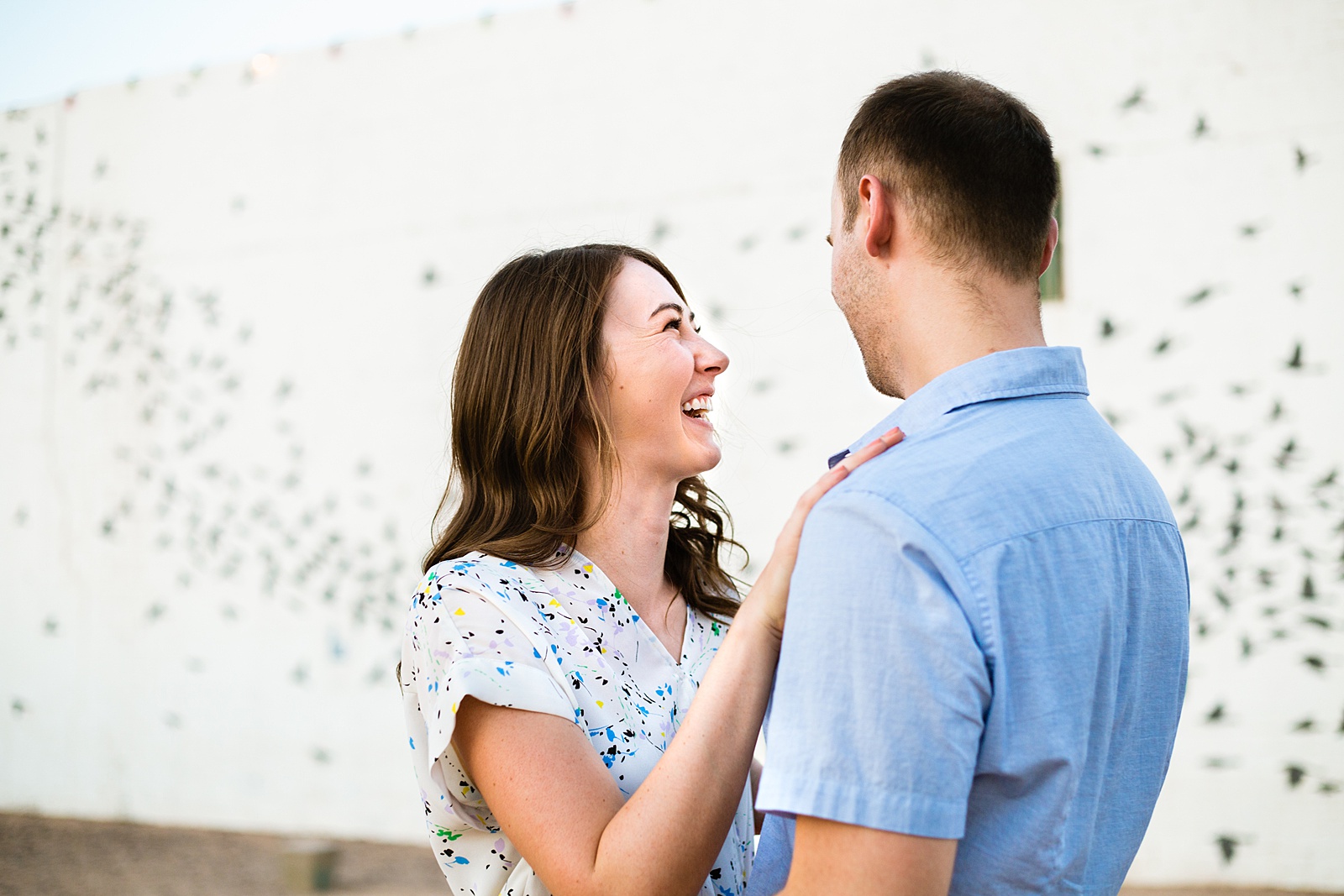 Couple laugh together during their Roosevelt Row engagement session by Phoenix engagement photographer PMA Photography.