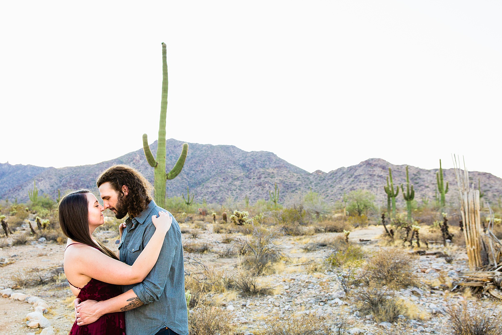 Couple share an intimate moment during their White Tanks engagement session by Phoenix engagement photographer PMA Photography.
