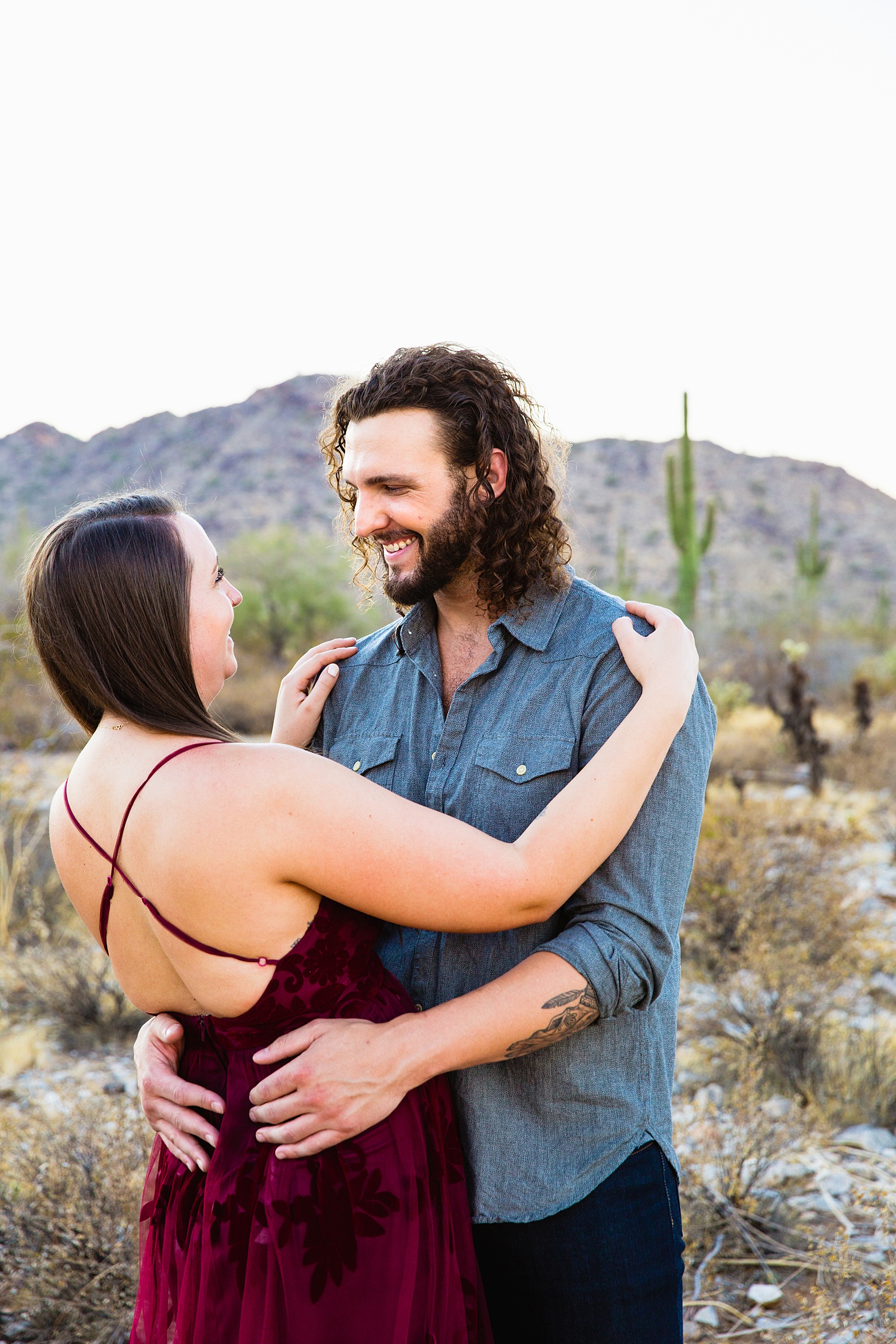 Couple laugh together during their White Tanks engagement session by Phoenix engagement photographer PMA Photography.