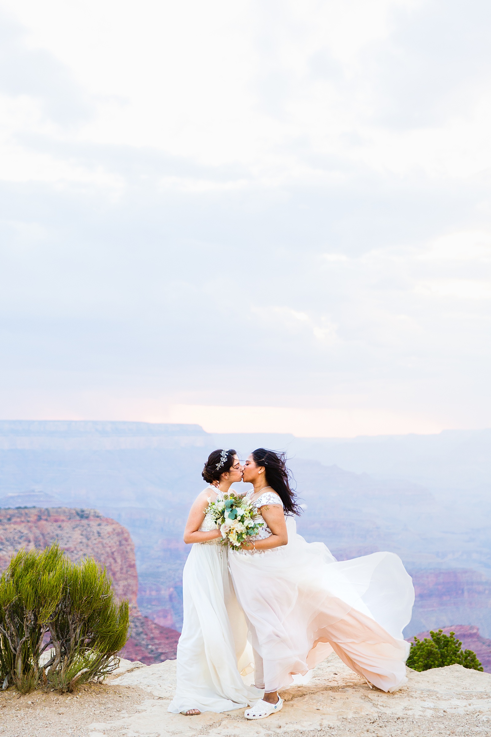 Adventurous LGBTQ+ couple share a kiss during their Moran Point elopement by Grand Canyon elopement photographer PMA Photography.